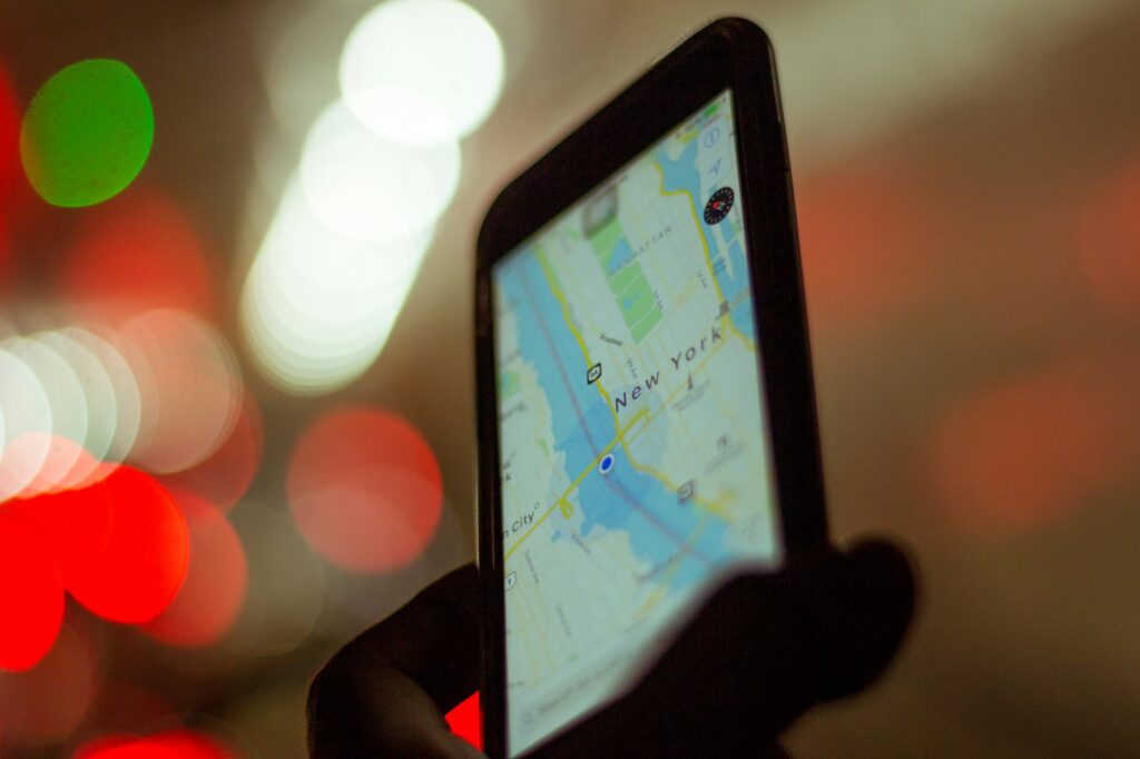 Personne tenant un smartphone affichant une carte GPS en voyage