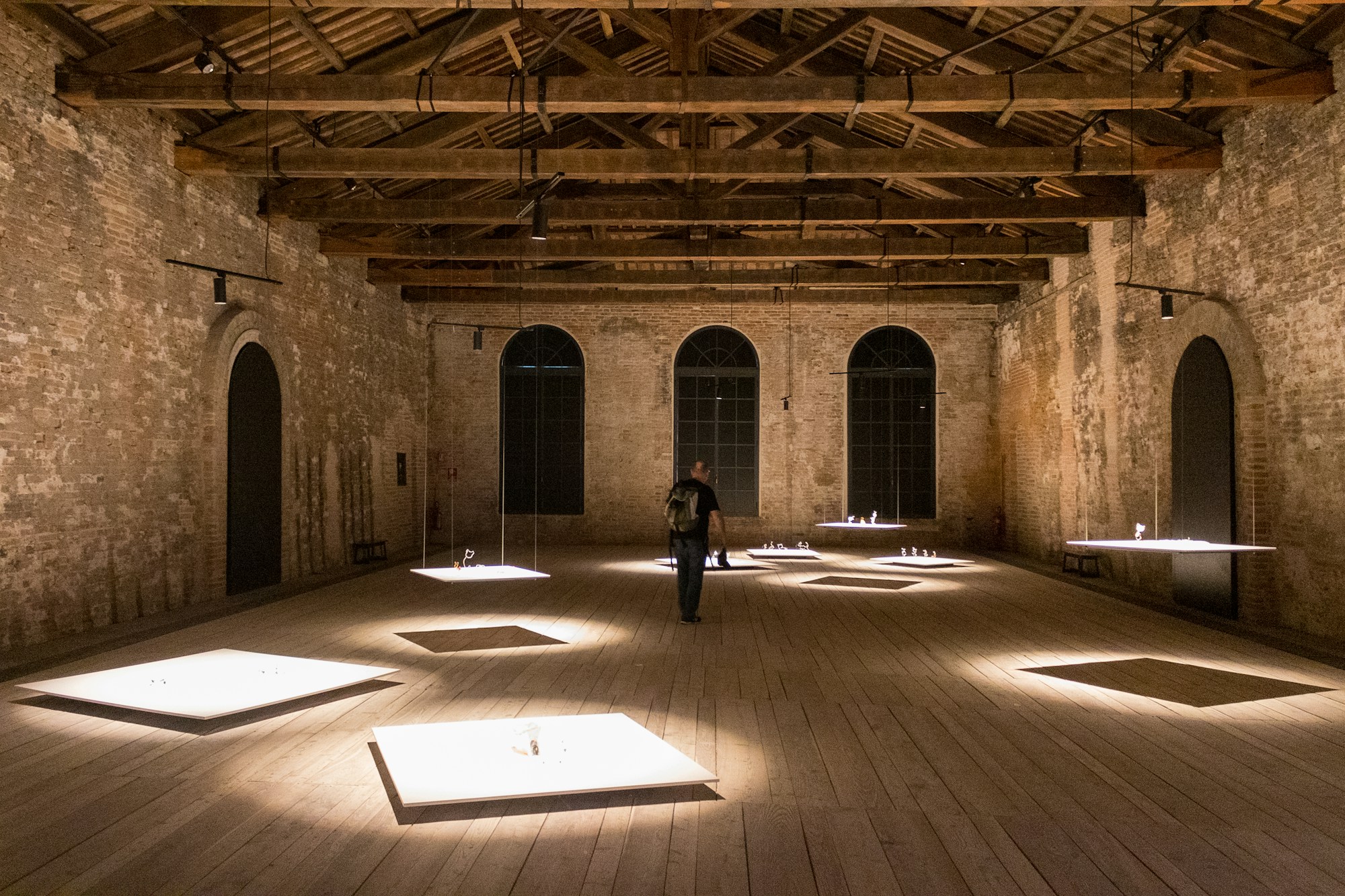 Installation lumineuse contemporaine dans les vastes nefs de briques rouges de l'Arsenale di Venezia lors d'une Biennale d'art