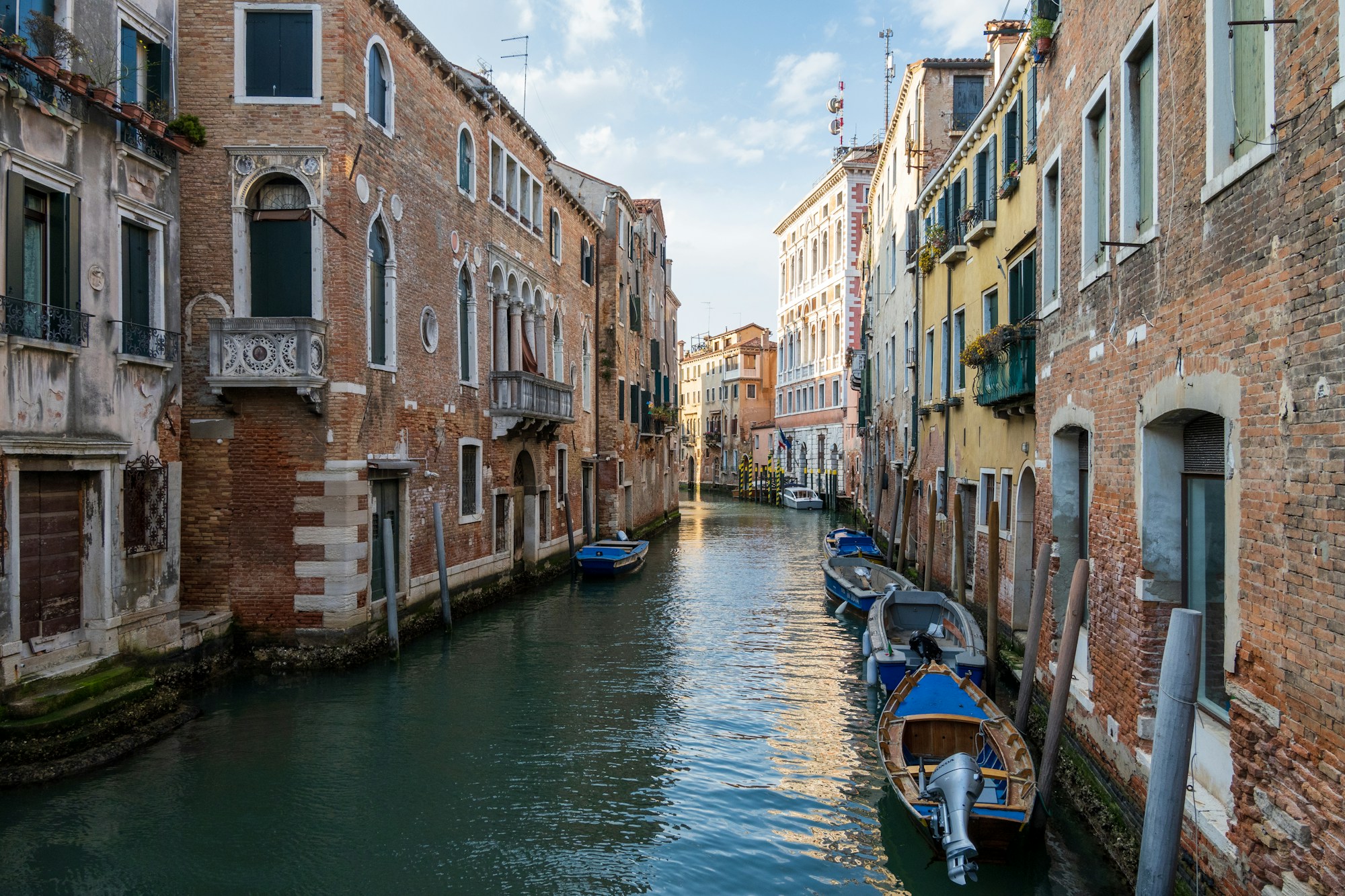 Canal vénitien animé avec gondoles et bâtiments colorés au bord de l'eau, sestiere de Venise