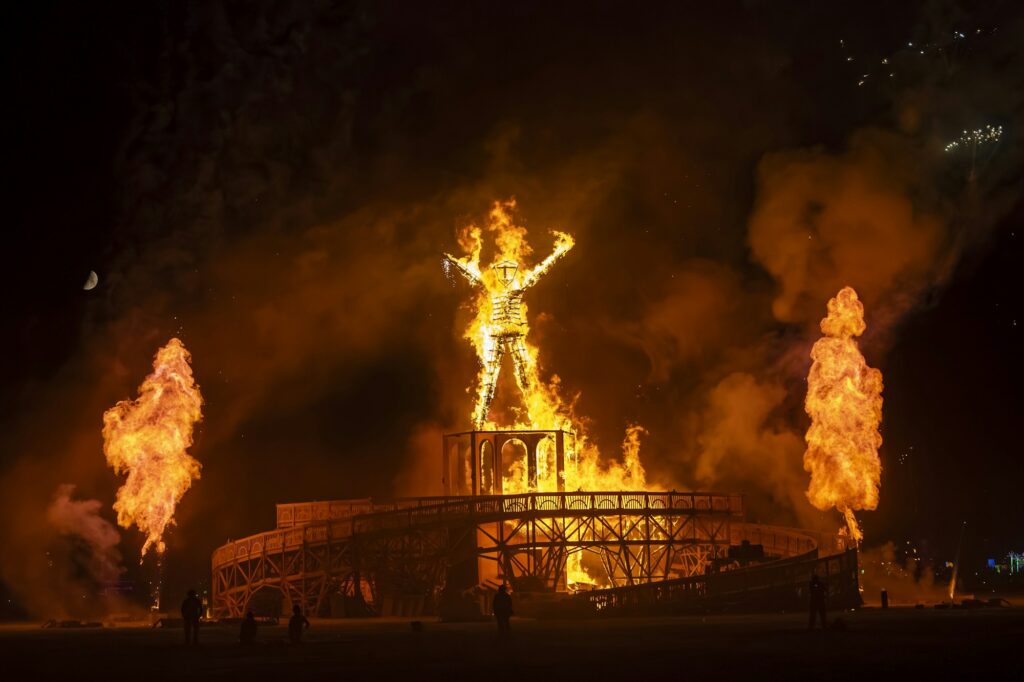 Le feu emblématique du Burning Man la nuit dans le désert de Black Rock City — Axis Mundi 2026