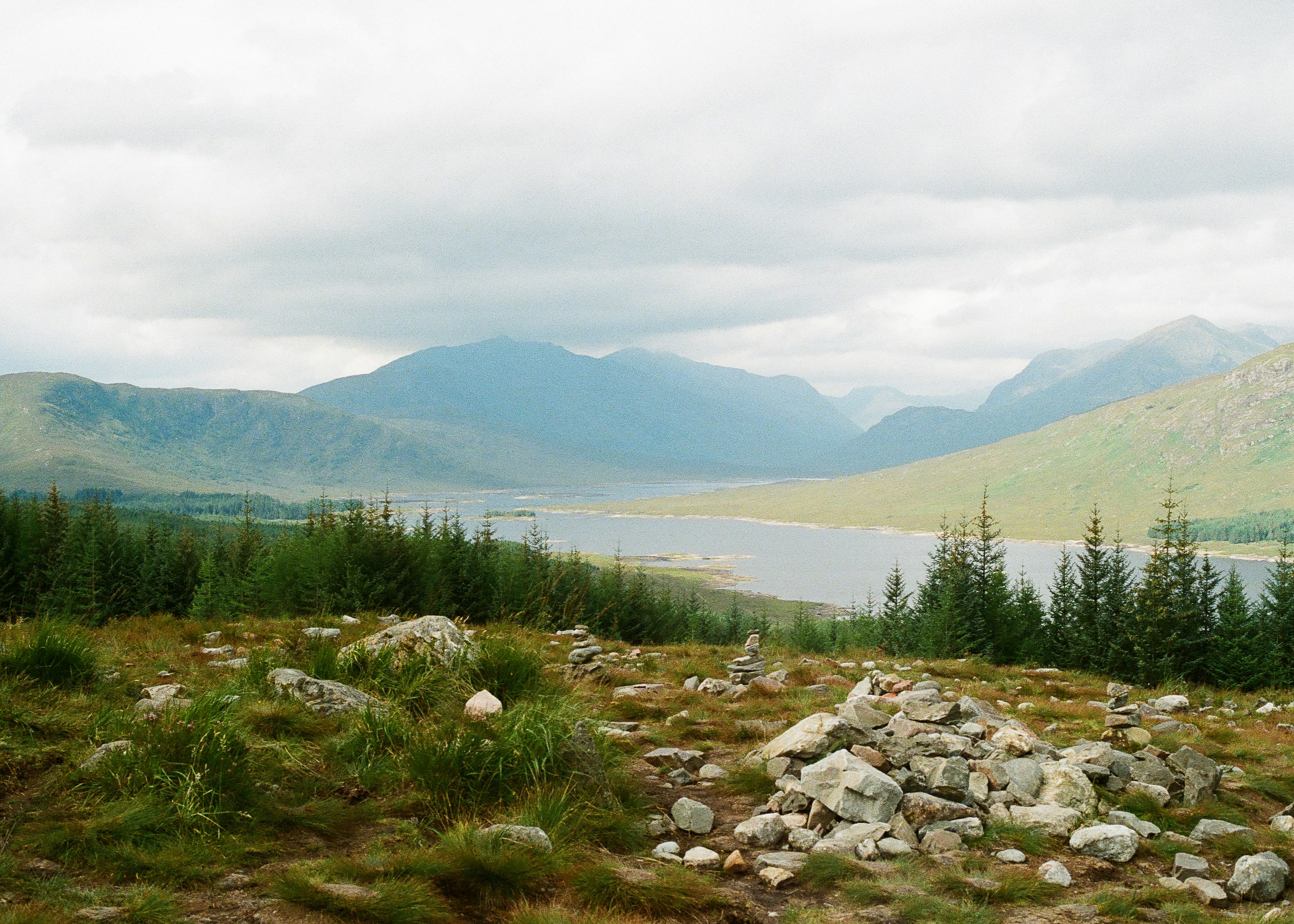 Scottish loch surrounded by green hills under a dramatic sky in the Highlands