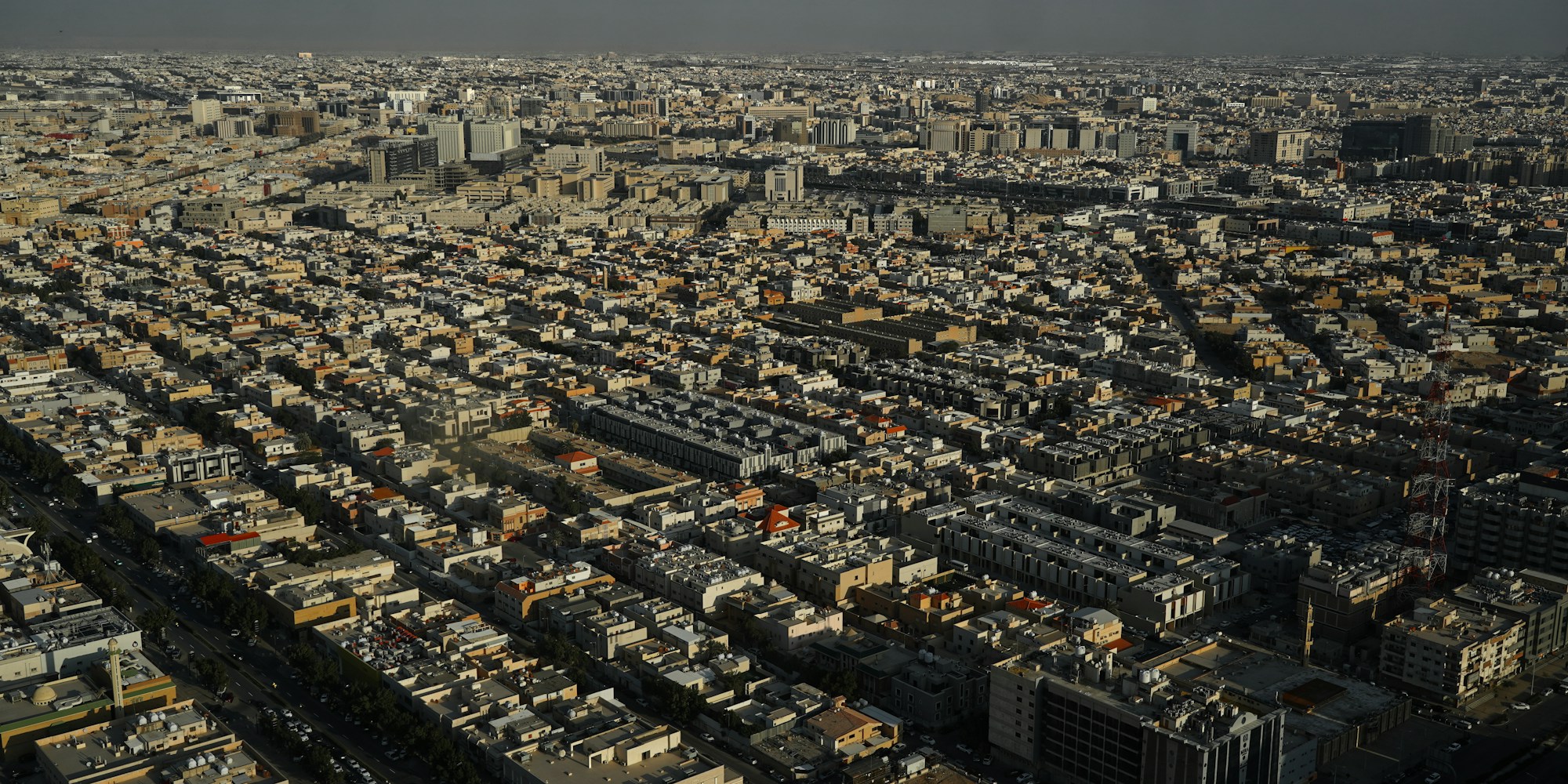 Aerial view of Riyadh, Saudi Arabia, with modern skyscrapers and the desert in the background