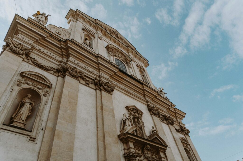 Façade majestueuse d'un bâtiment viennois baroque avec statues dorées sous un ciel bleu, symbole de l'architecture impériale de Vienne