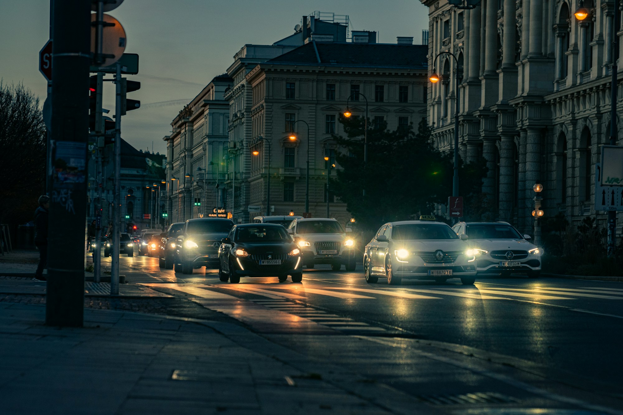 Belebte Wiener Straße bei Nacht mit Verkehr und Leuchtreklamen, Bezirk Rudolfsheim-Fünfhaus nahe der Wiener Stadthalle