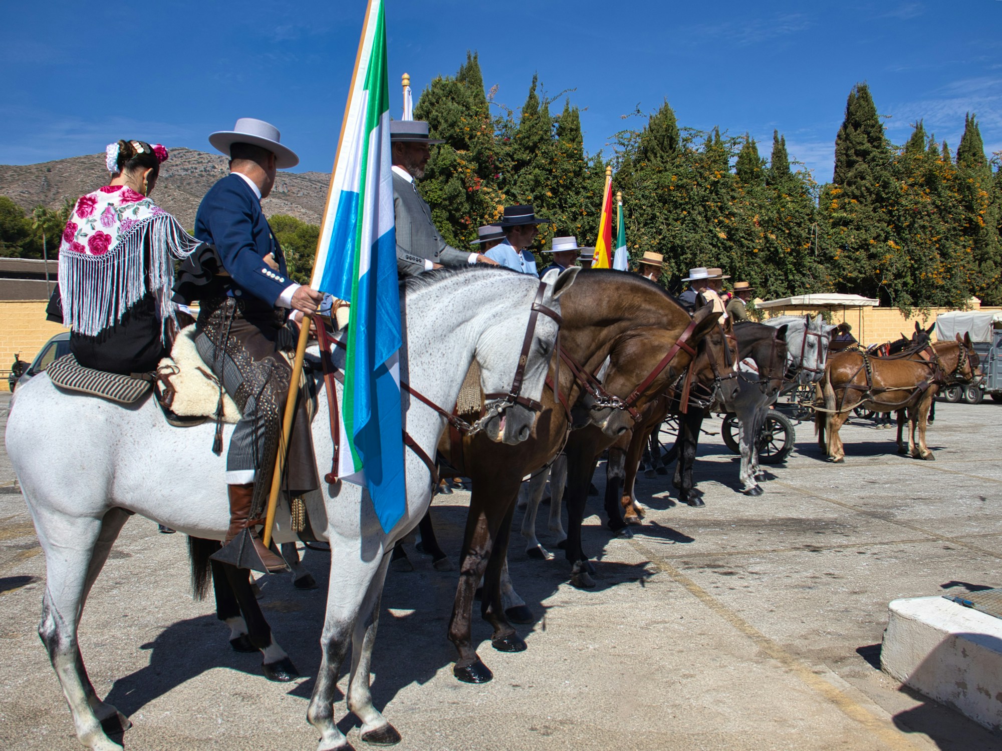 Cavaliers en tenue traditionnelle avec drapeaux lors du Paseo de Caballos de la Feria del Caballo