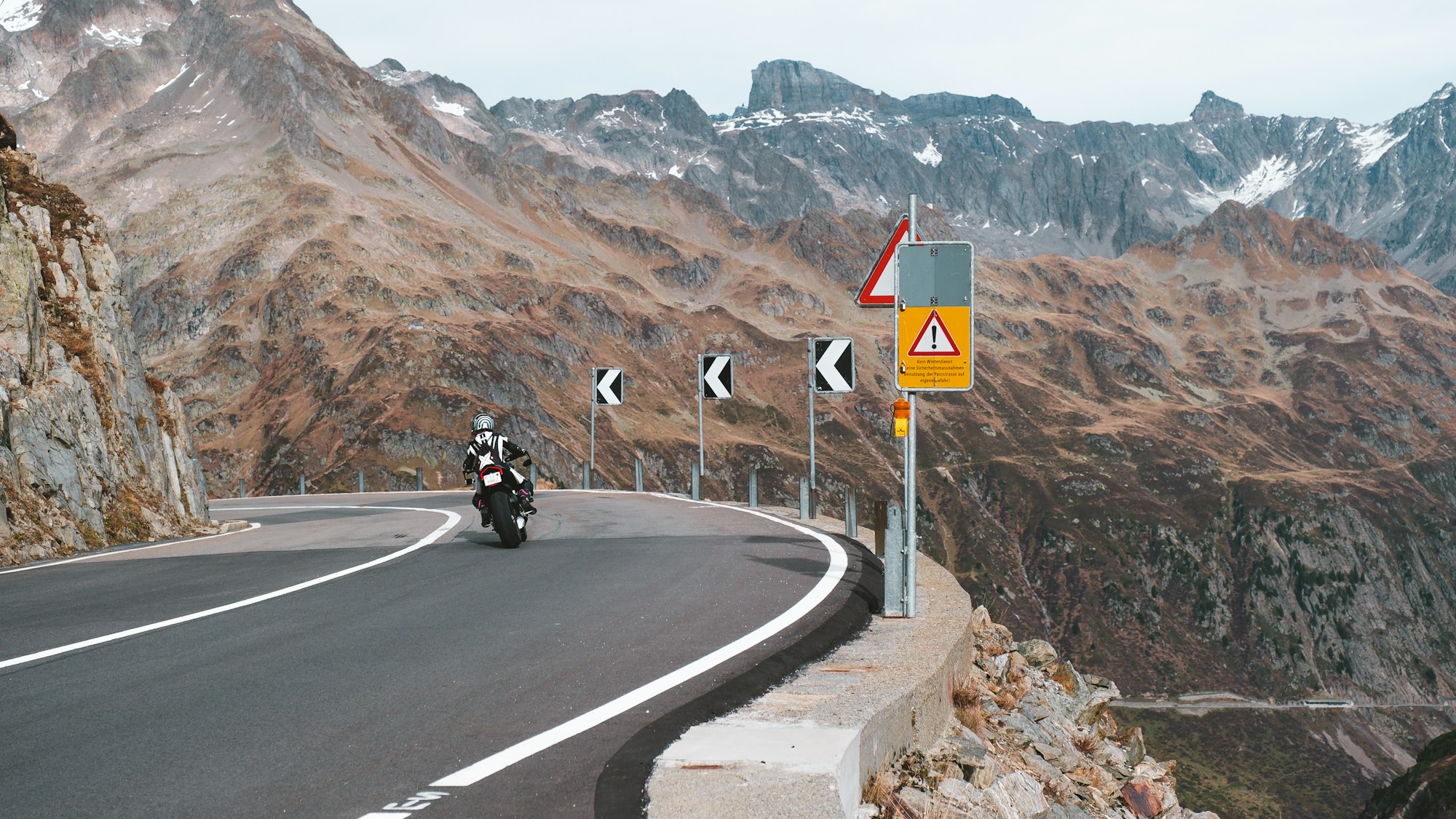 Motocycliste sur une route de montagne sinueuse dans les Alpes françaises en été