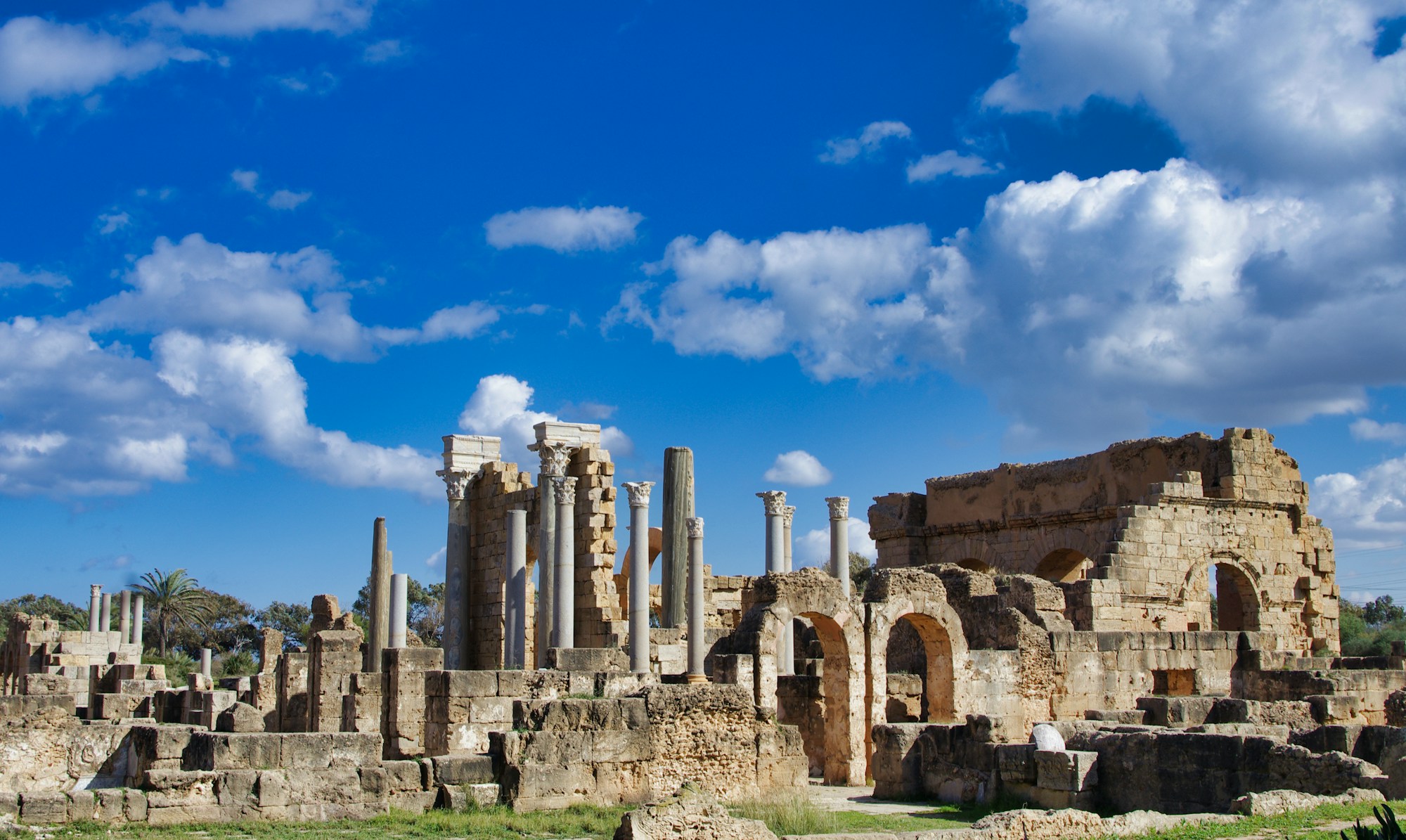 Colonnes et thermes des ruines romaines de Leptis Magna en Libye, sous un ciel bleu méditerranéen