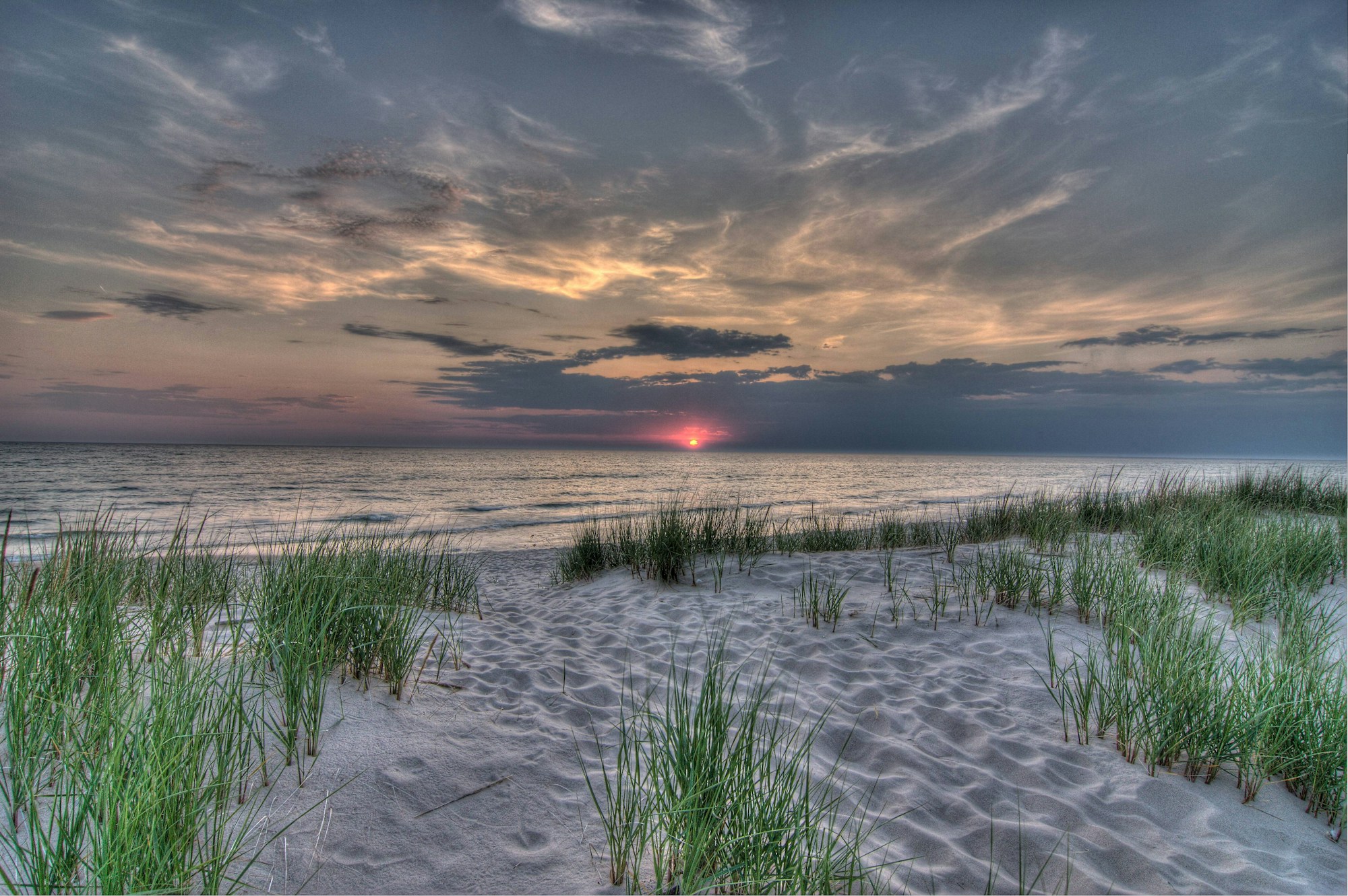 Coucher de soleil depuis une plage du lac Michigan côté Michigan, reflets orangés sur l'eau