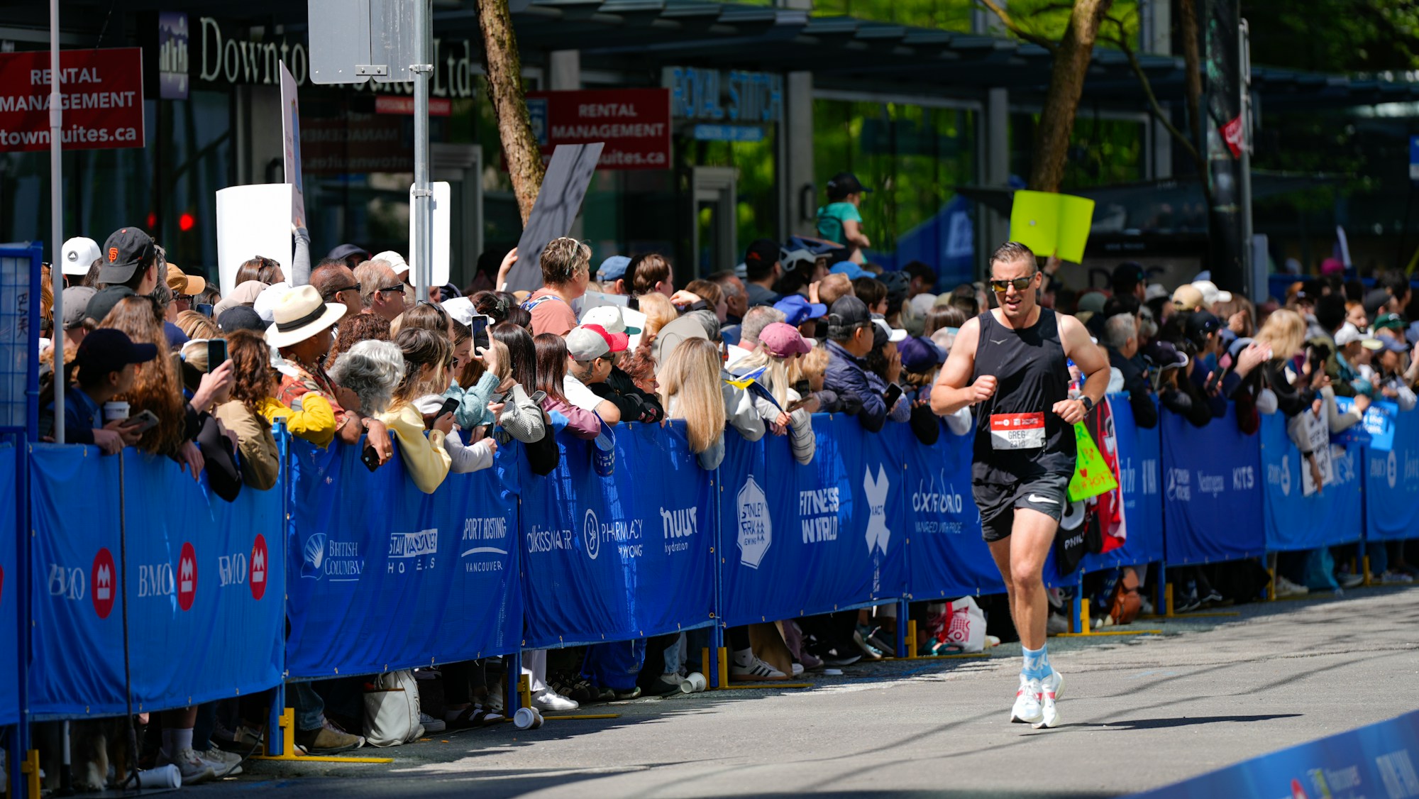 Runner passing enthusiastic spectators behind barriers at a city marathon