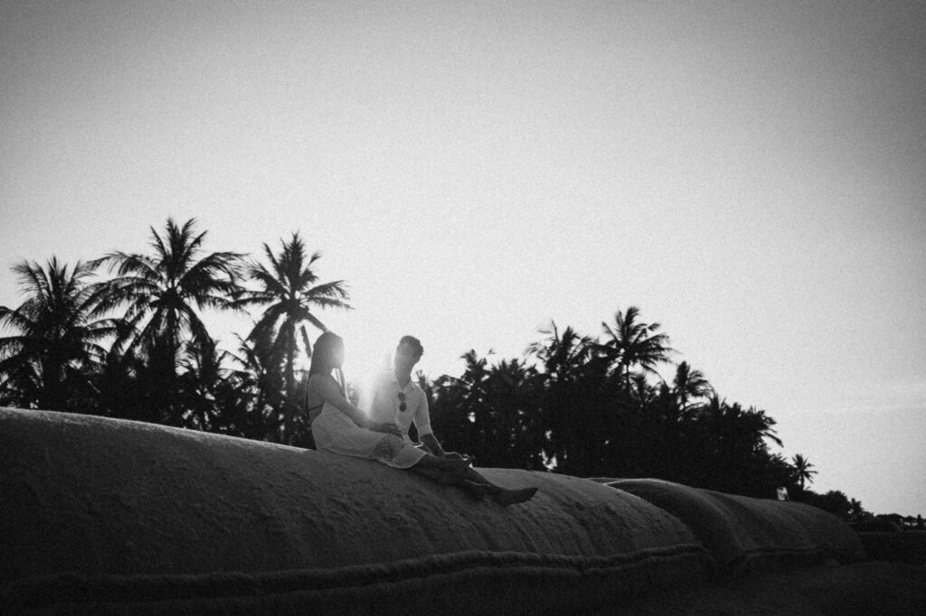 Couple en voyage de noces dans un bungalow sur pilotis face à un lagon turquoise