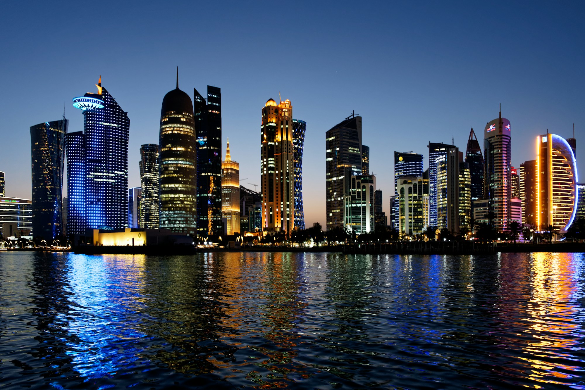 Skyline nocturne de Doha, Qatar — reflets des gratte-ciels sur la baie du Golfe Persique