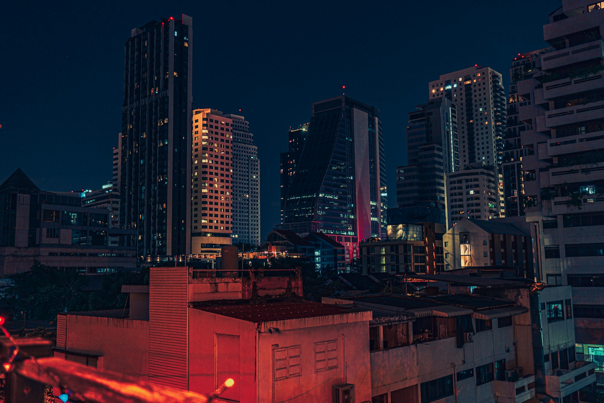 Elevated view of Bangkok's illuminated skyline at night, with Benjakitti Park below, Thailand
