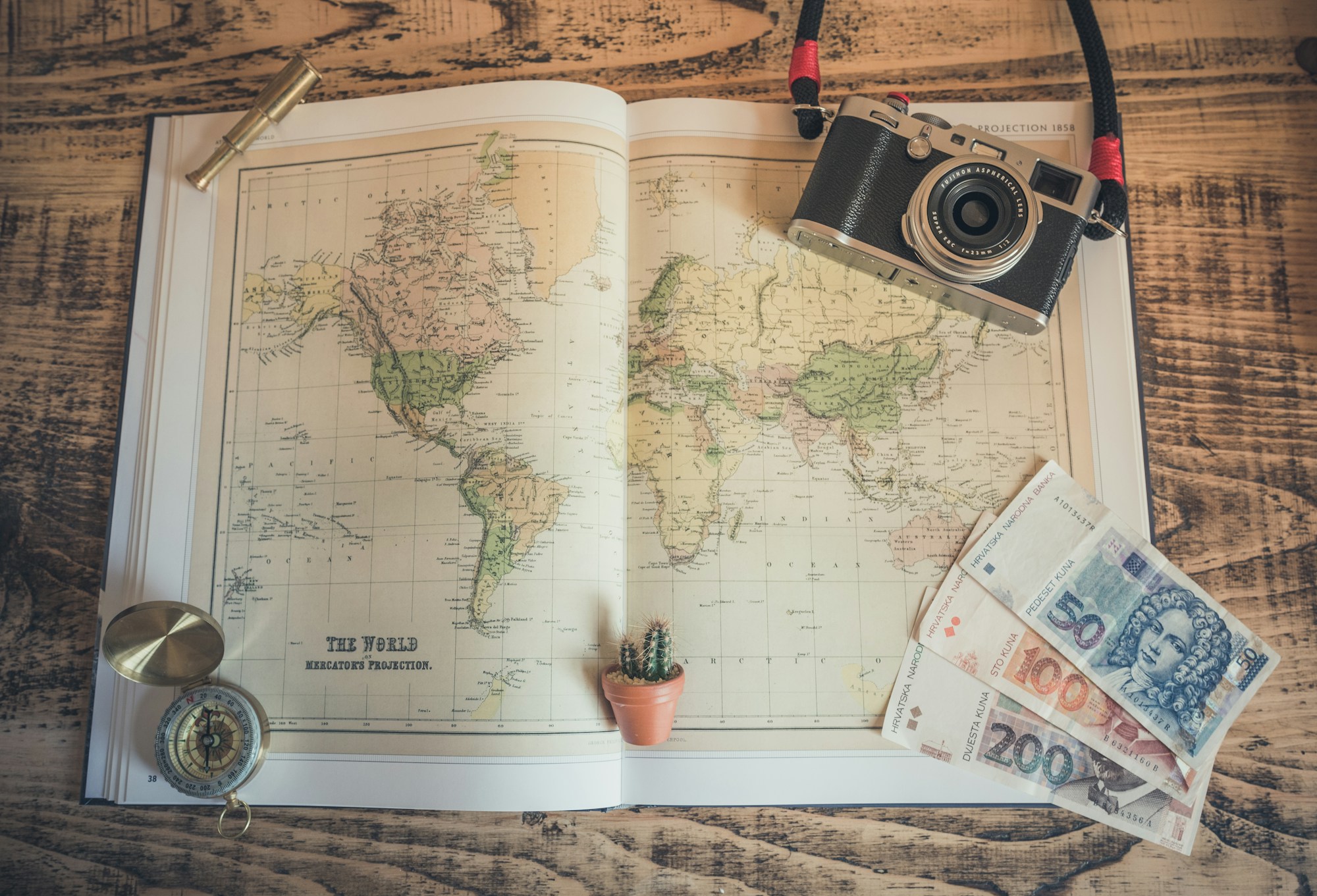 Carte du monde avec boussole et appareil photo — planifier son voyage 2026
