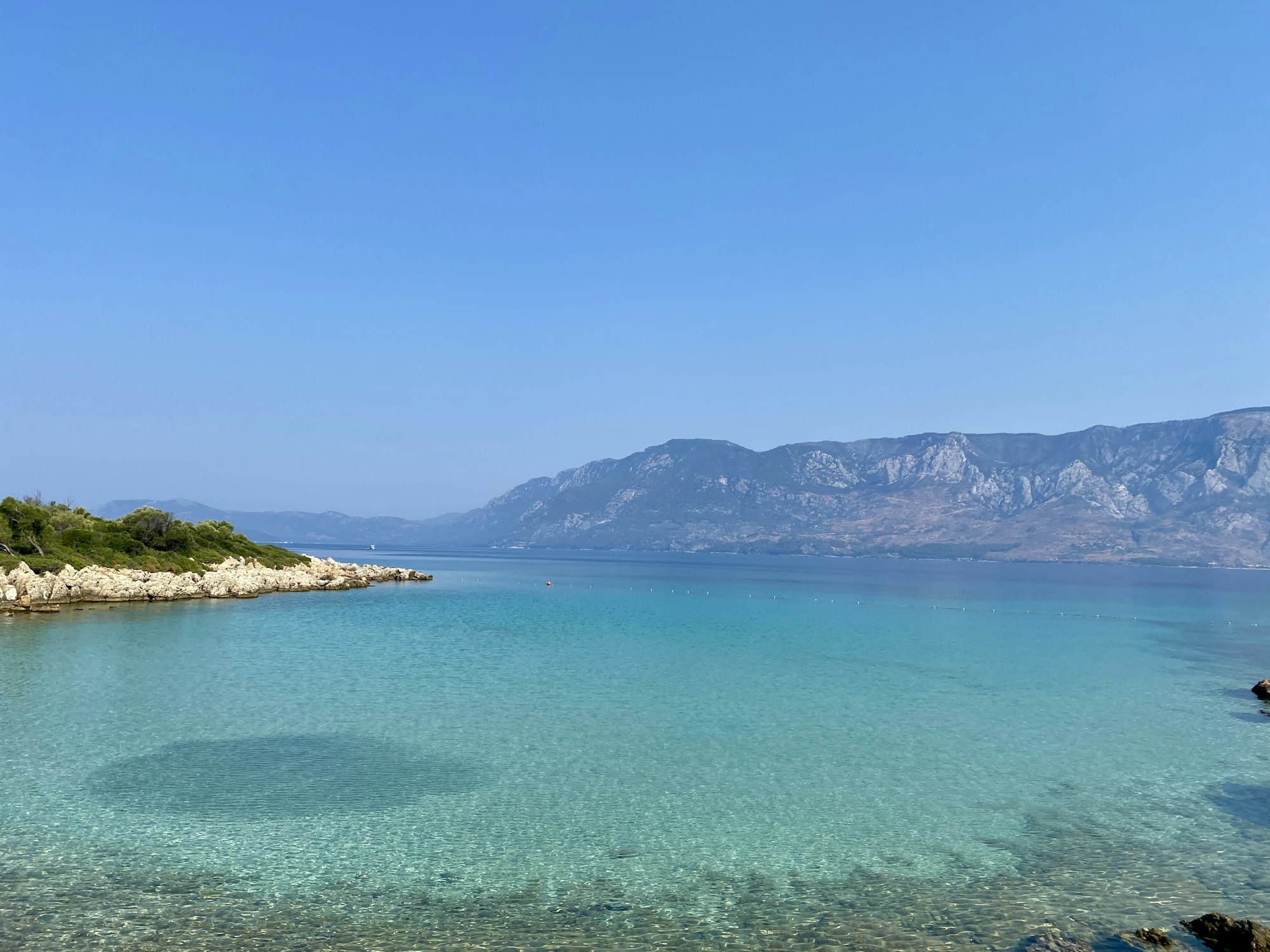 Crystal-clear turquoise waters of the Albanian Riviera with mountains in the background