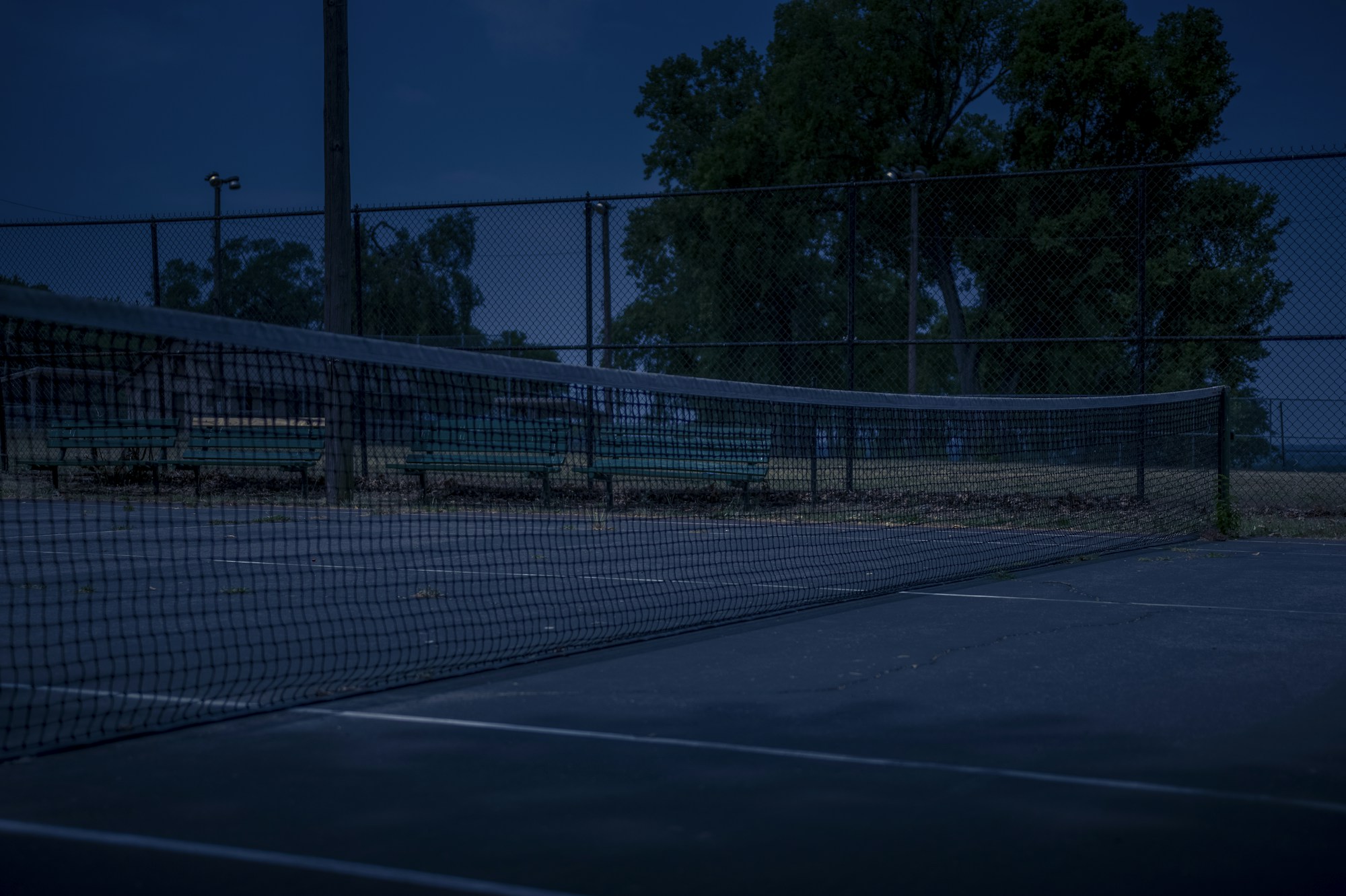 Philippe-Chatrier court at Roland-Garros lit up at night under its closed retractable roof, stands bathed in a dramatic atmosphere