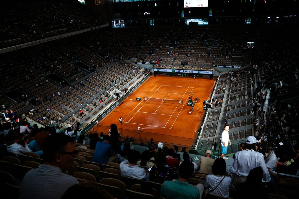 Match de tennis dans un grand stade avec tribunes remplies de spectateurs lors d'une session journée
