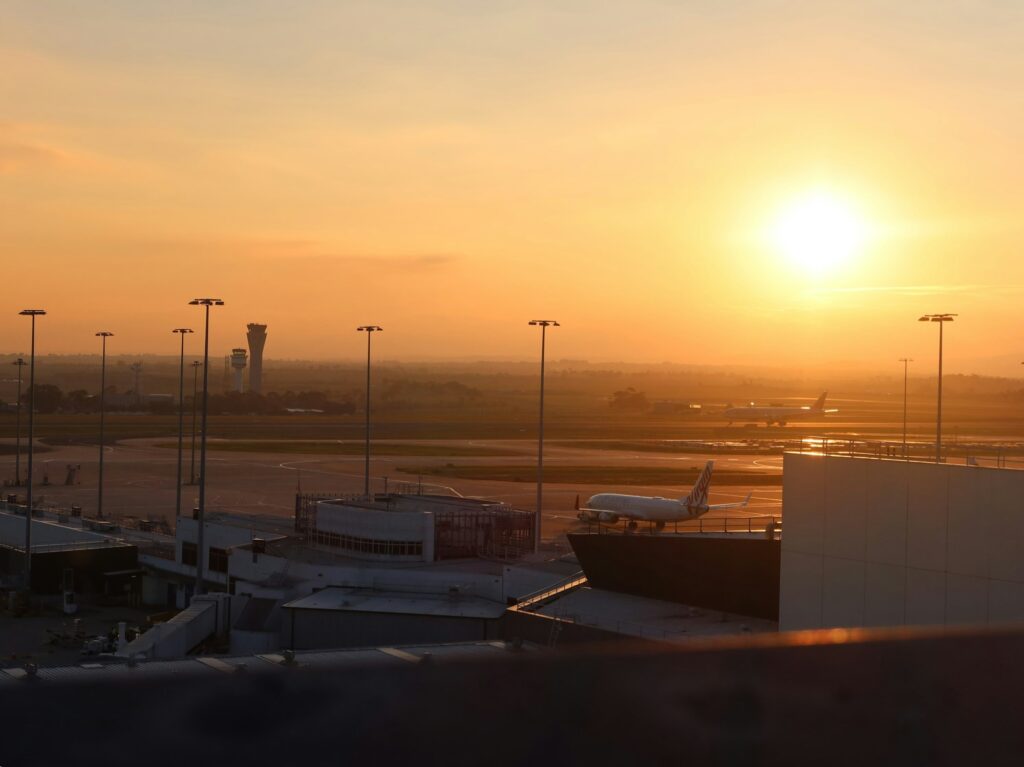Coucher de soleil sur un aéroport avec un avion sur le tarmac — transition vers les carburants durables