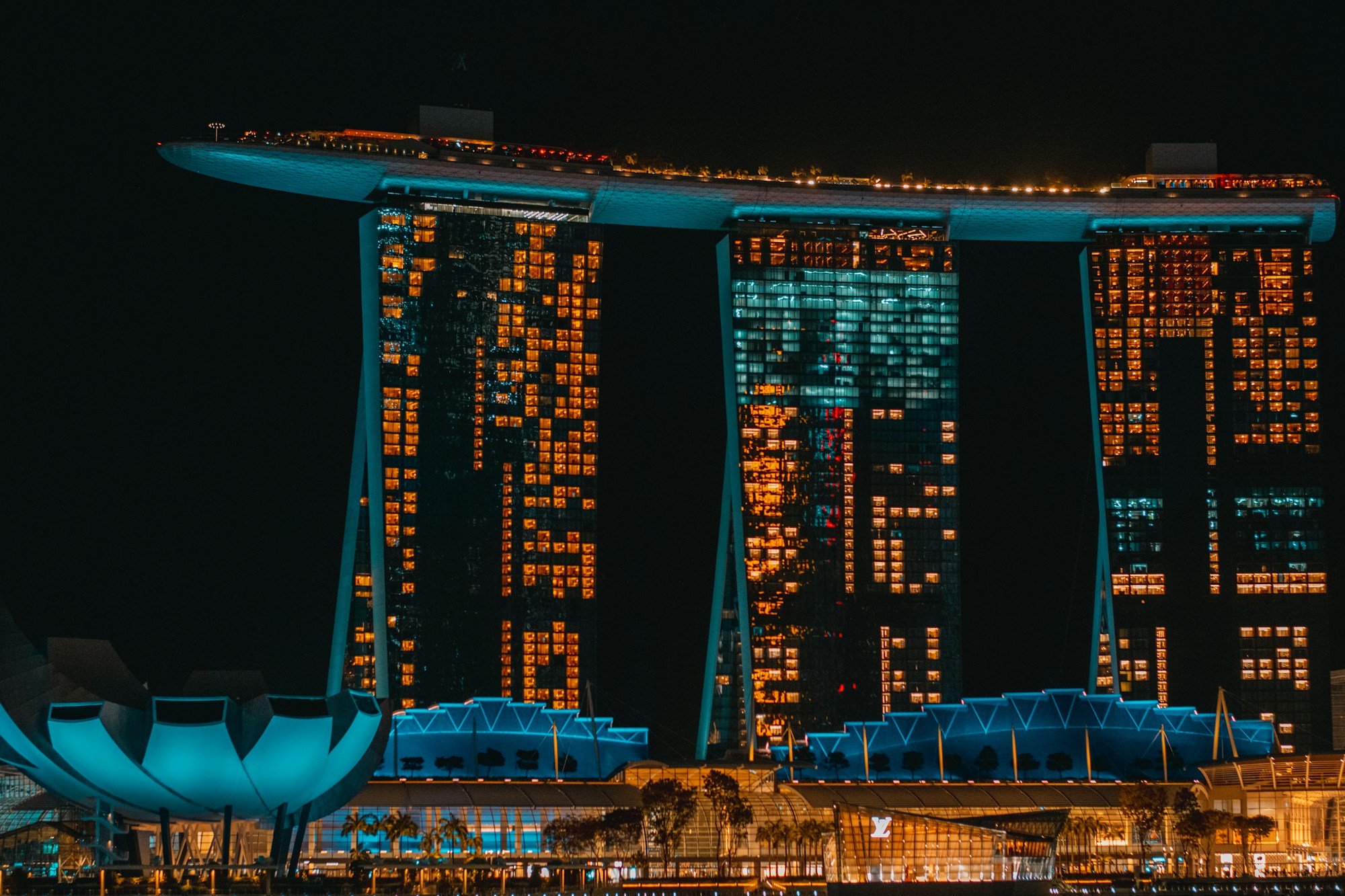 View of the illuminated Marina Bay Sands towers and Singapore harbour at night
