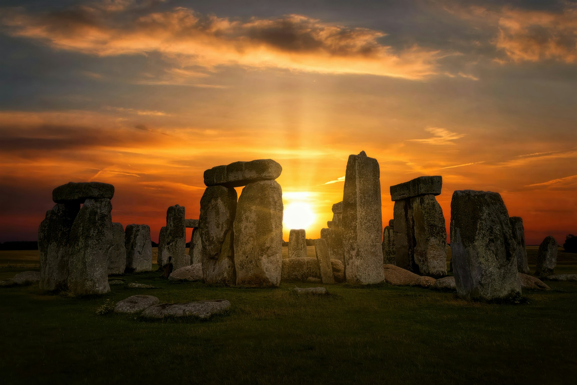 Stonehenge en silueta contra un cielo dorado al amanecer, llanura de Salisbury