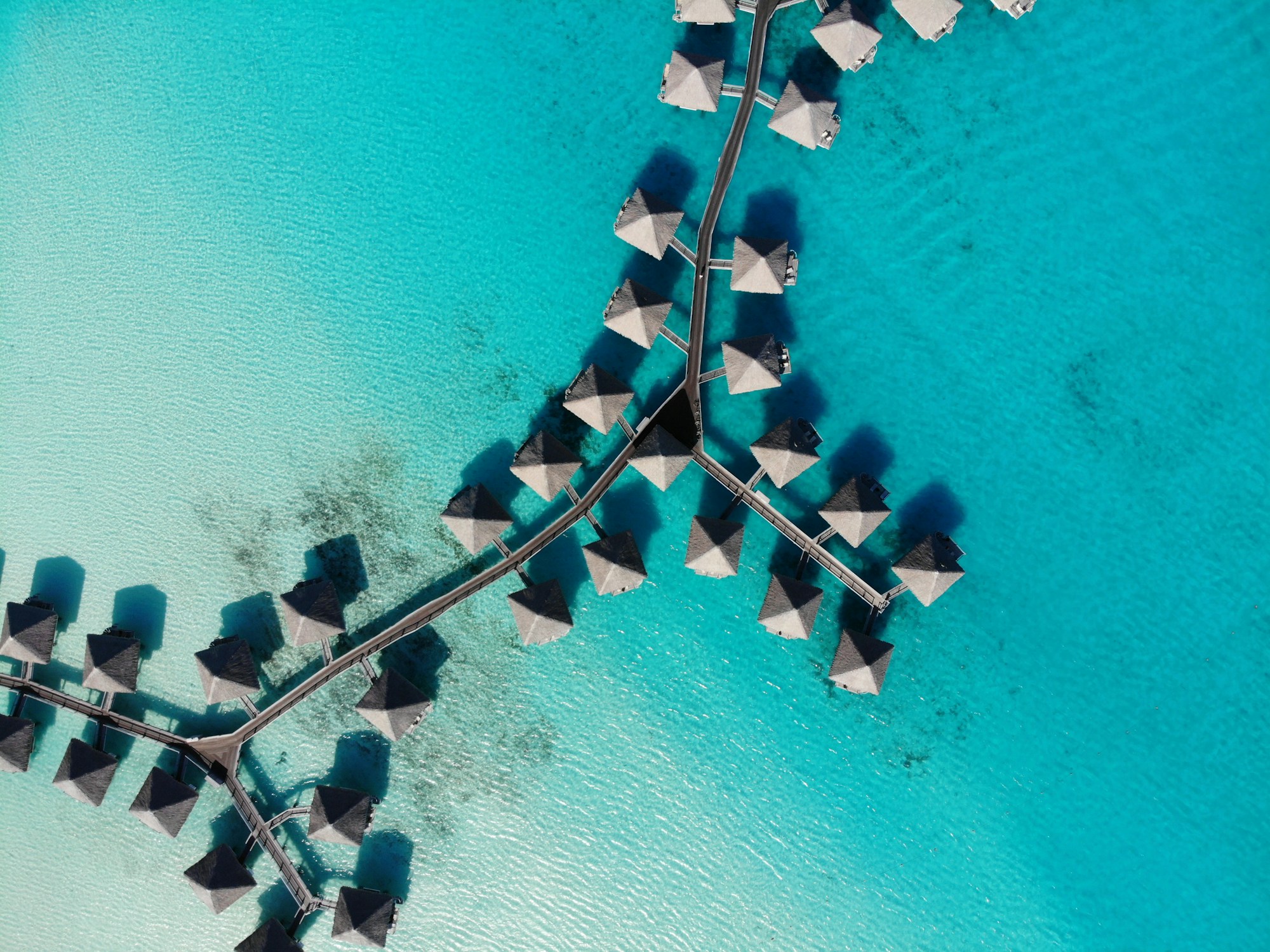 Bungalows sur pilotis surplombant le lagon turquoise de Bora Bora, Polynésie française
