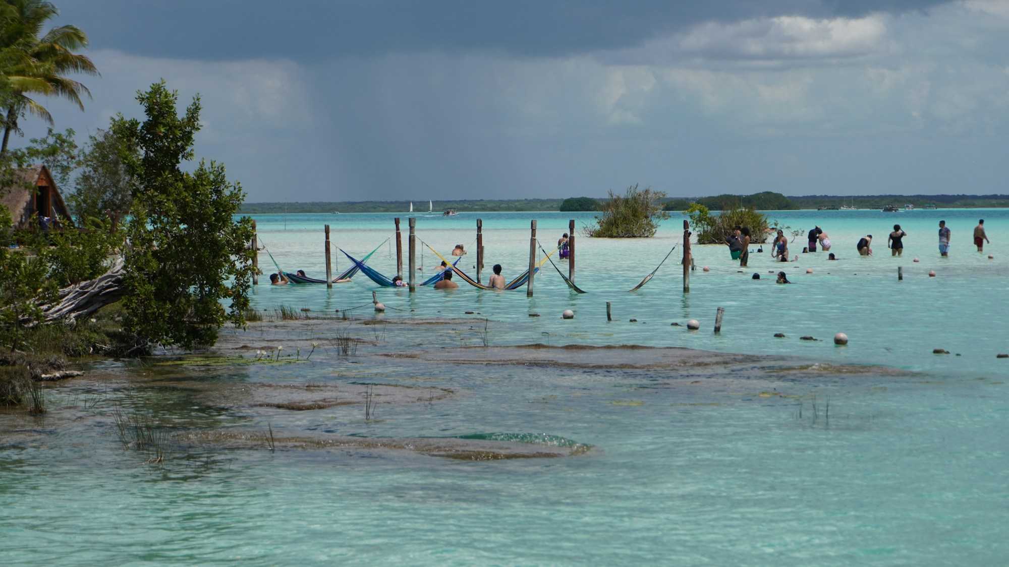 Hammac suspendu au-dessus d'eaux turquoise cristallines dans les Caraïbes mexicaines