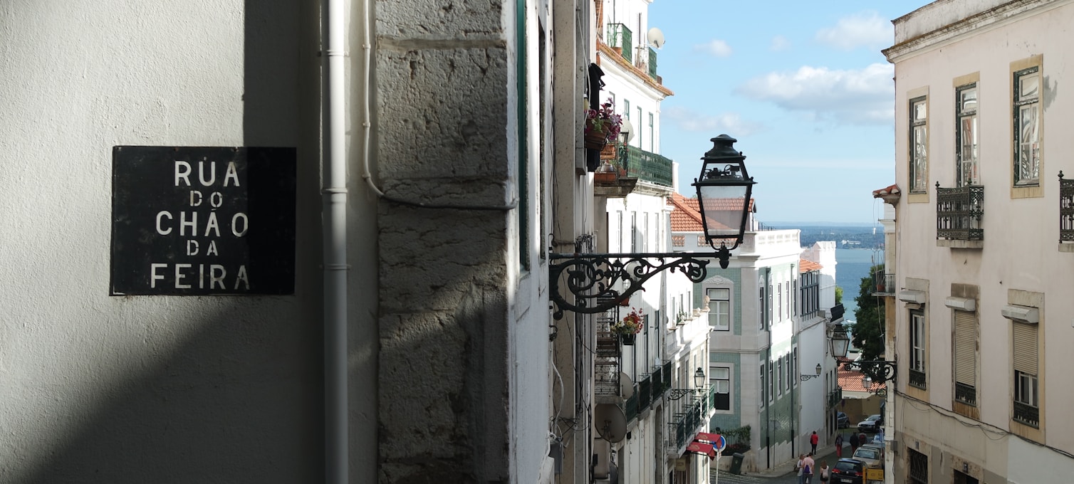 Ruelles d'Alfama à Lisbonne avec façades couvertes d'azulejos et linge étendu entre les maisons