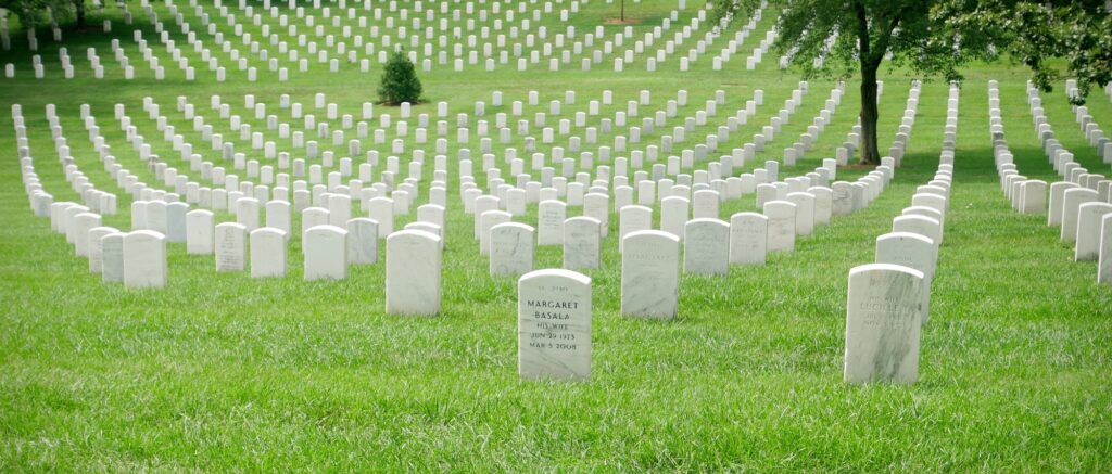 Rangées de croix blanches dans un cimetière militaire sur pelouse verte en Normandie