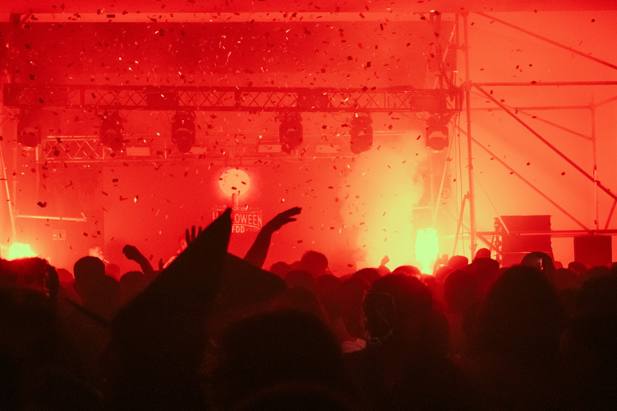 Foule en concert sous les lumières rouges et la fumée — ambiance festival de musique