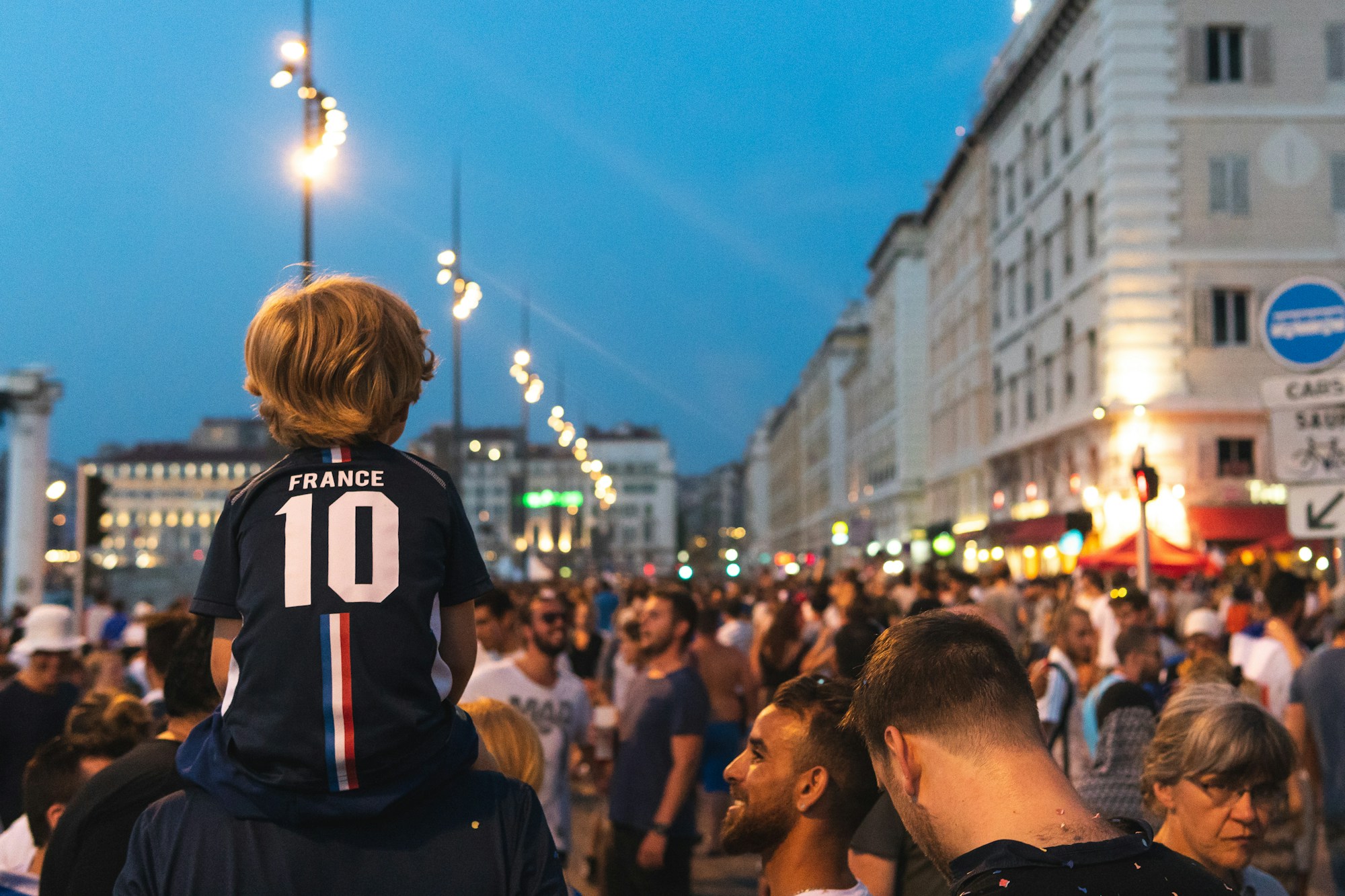 Famille avec enfants au bord d'une route lors d'une fête populaire en France