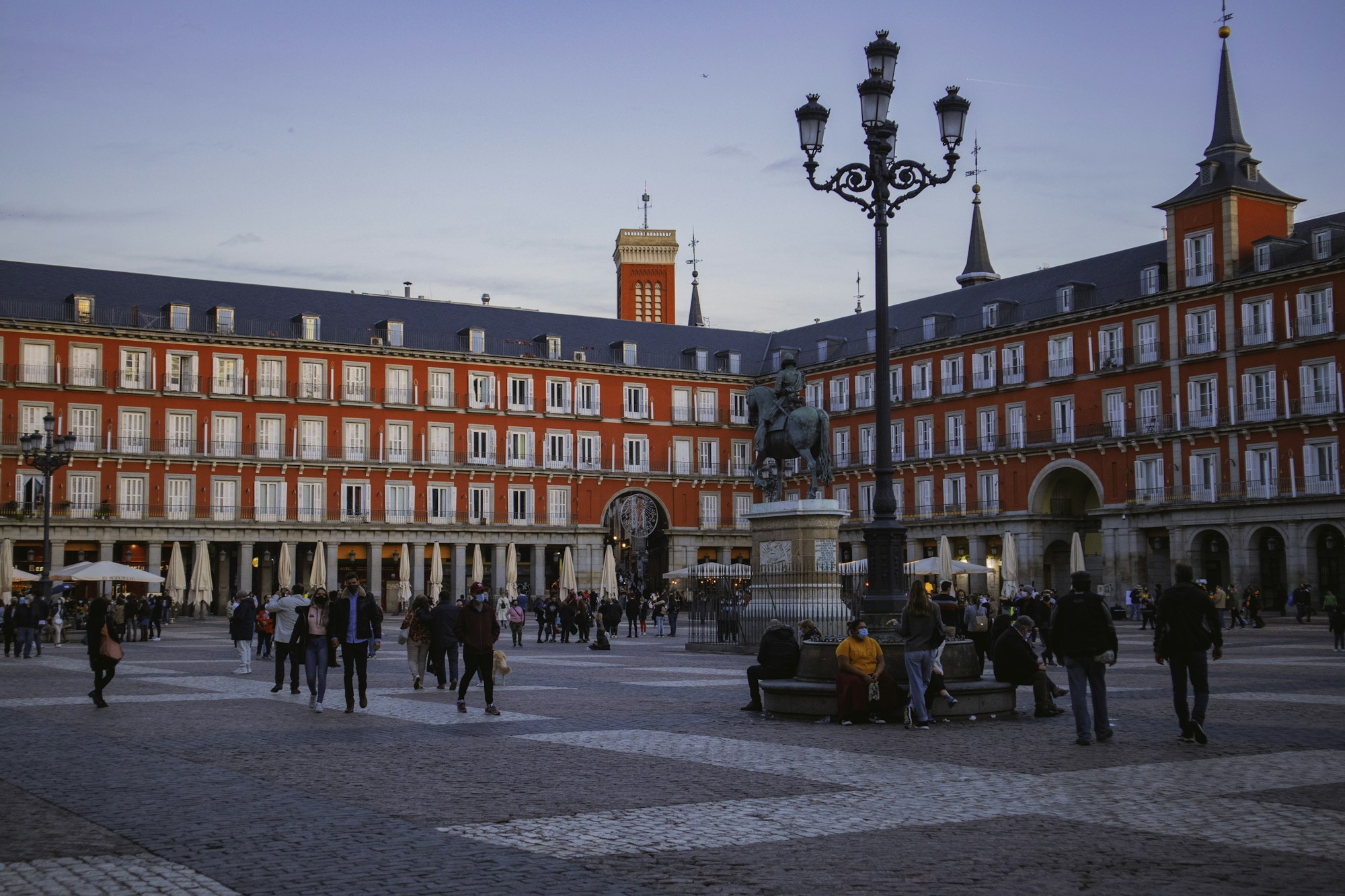 Place animée de Madrid en soirée, architecture baroque et ambiance festive