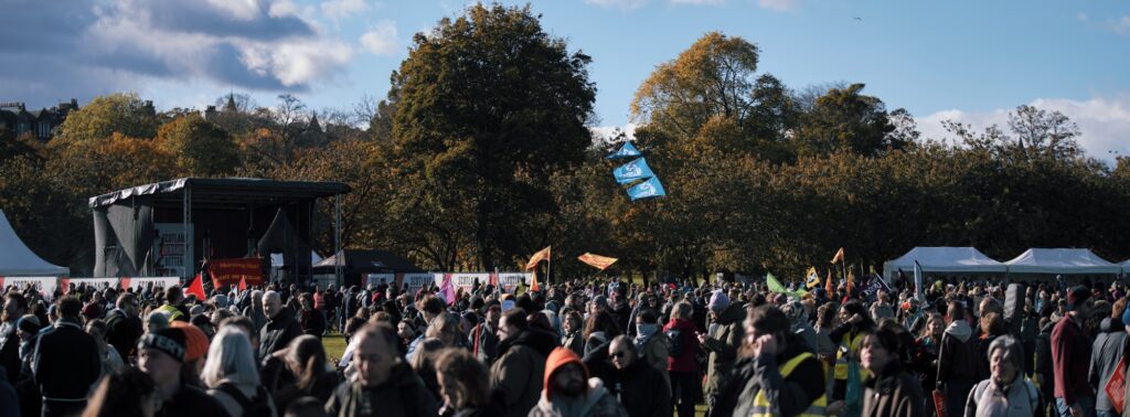 Foule en transe devant la scène principale d'un festival de rock en plein air, lumières scéniques et fumée