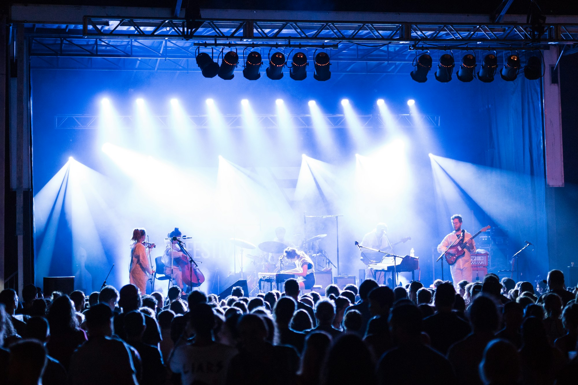 Groupe de rock sur scène avec effets de fumée et lumières laser lors d'un festival en plein air