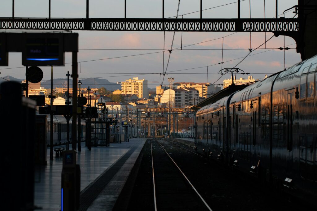 Voyageurs sur un quai de gare la nuit, train en partance vers le festival