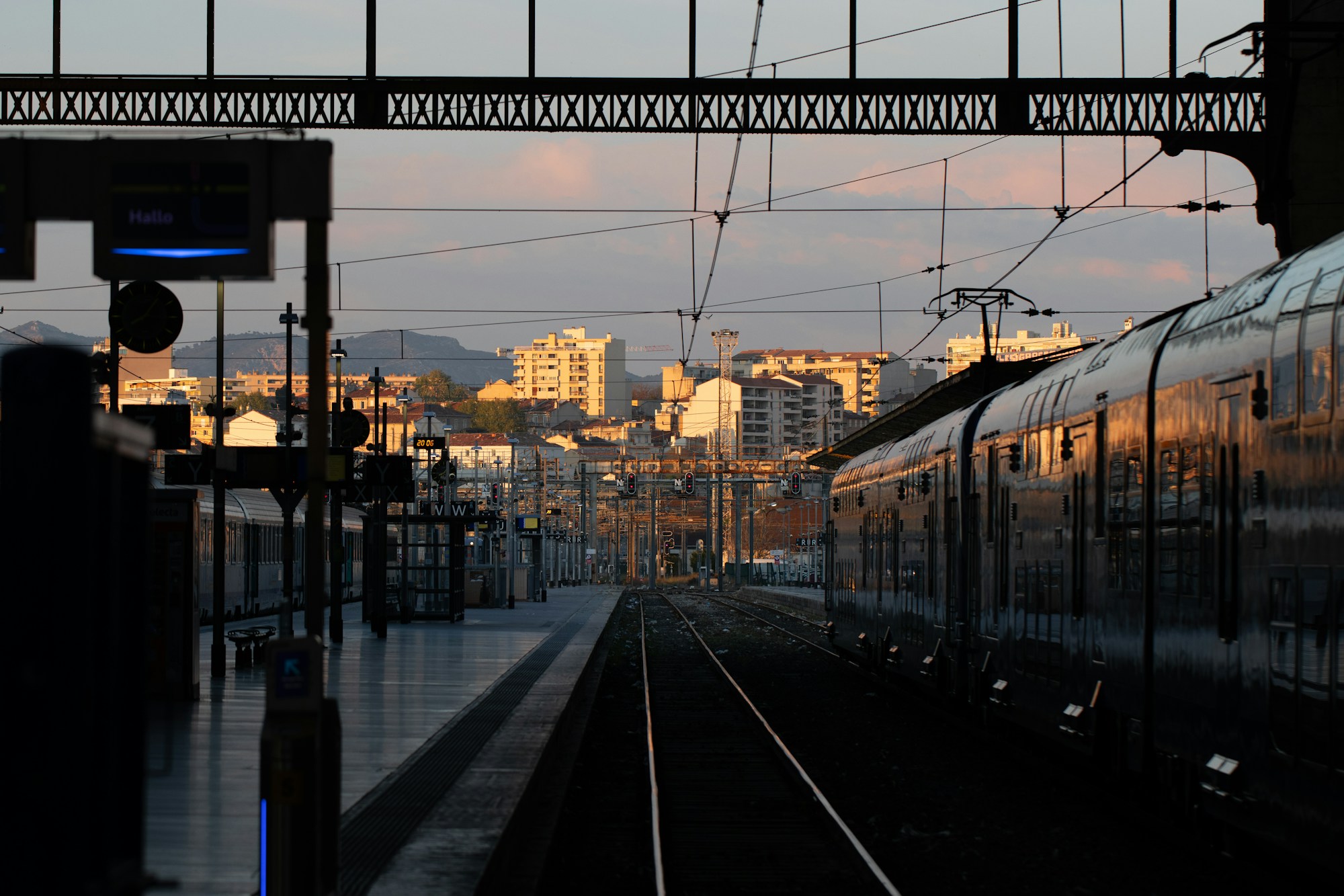Travellers on a station platform at night, train departing for a music festival