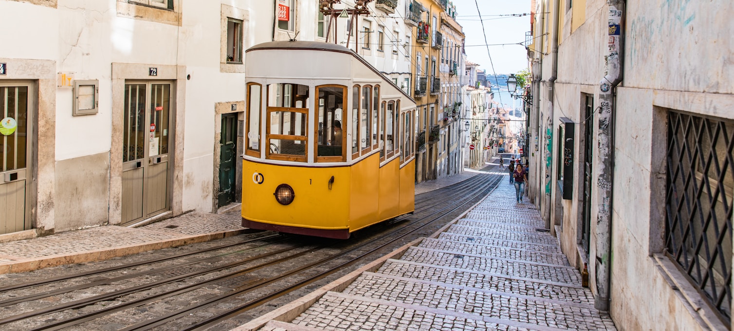 Tramway 28 de Lisbonne dans les ruelles d'Alfama au coucher du soleil avec façades carrelées d'azulejos