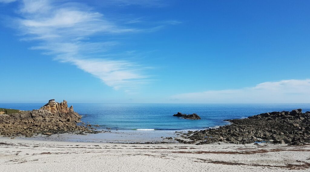 Côte sauvage de Bretagne en été — falaises, rochers et mer bleue sous le soleil