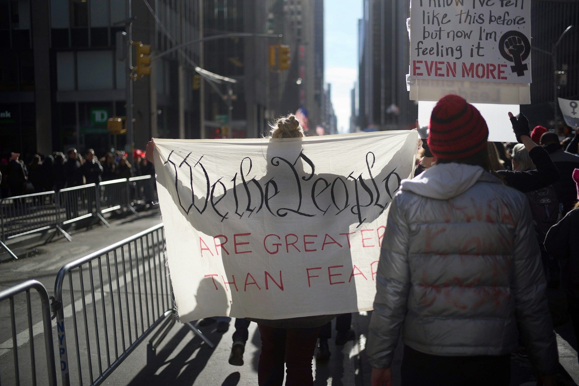 Rassemblement militant dans les rues de New York avec pancartes et drapeaux arc-en-ciel