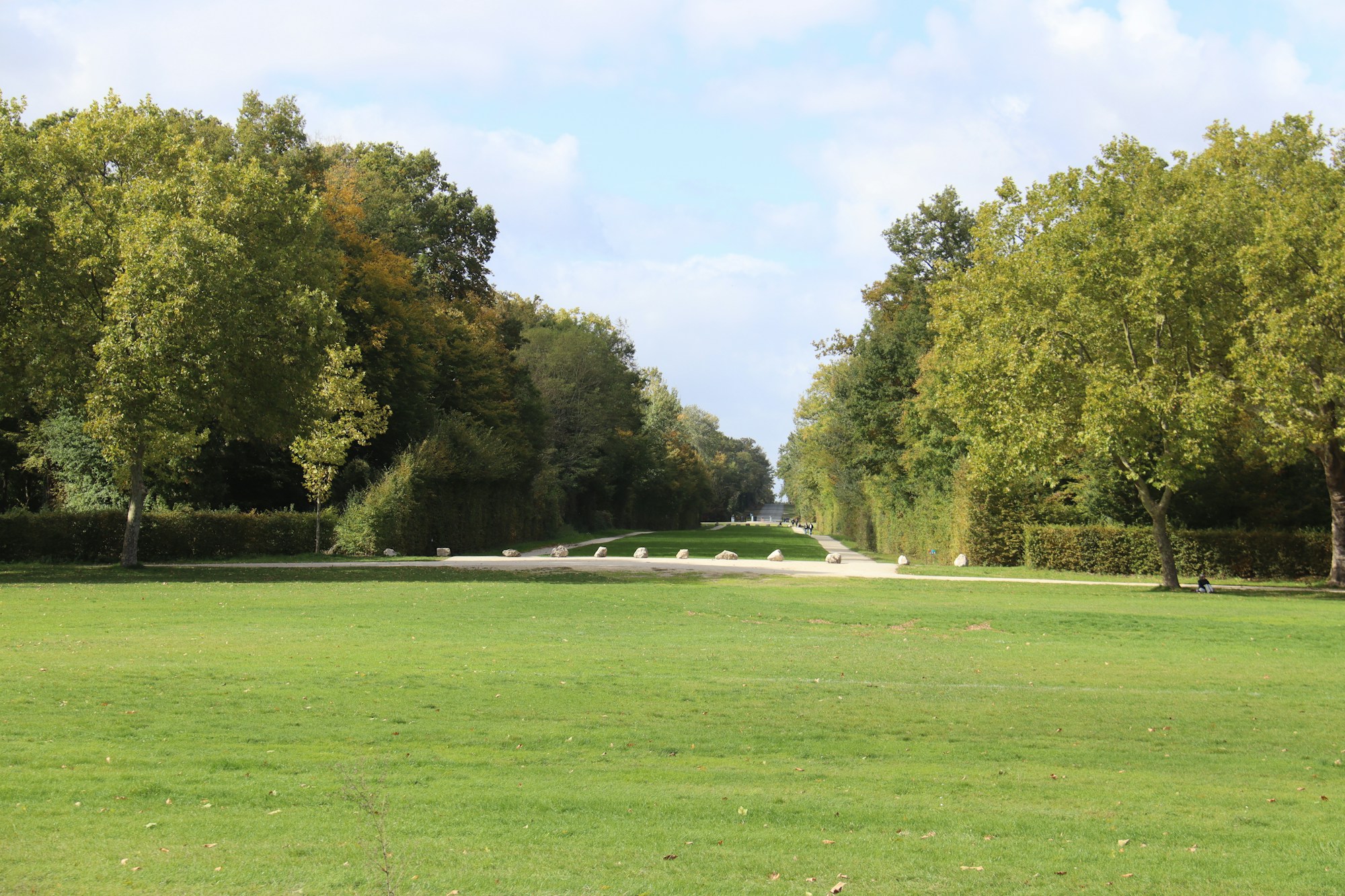 Parc ornemental européen au printemps avec allées de tilleuls et pelouses taillées
