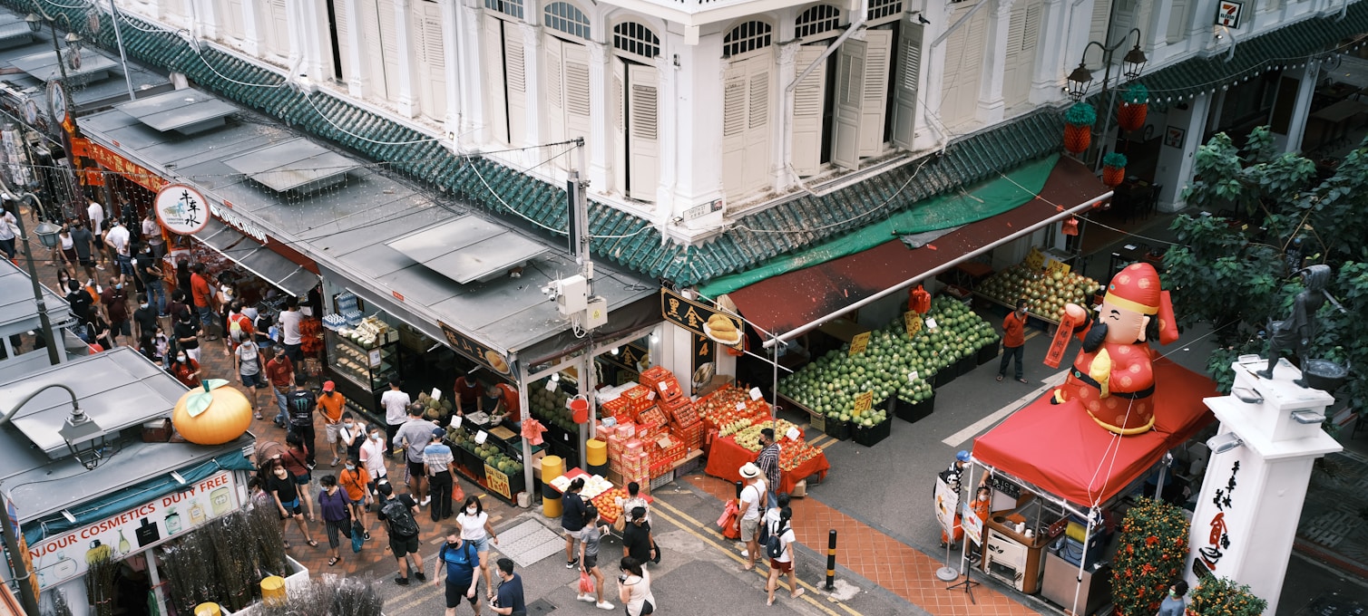 Hawker centre animé de Singapour avec étals colorés et voyageurs en train de déguster