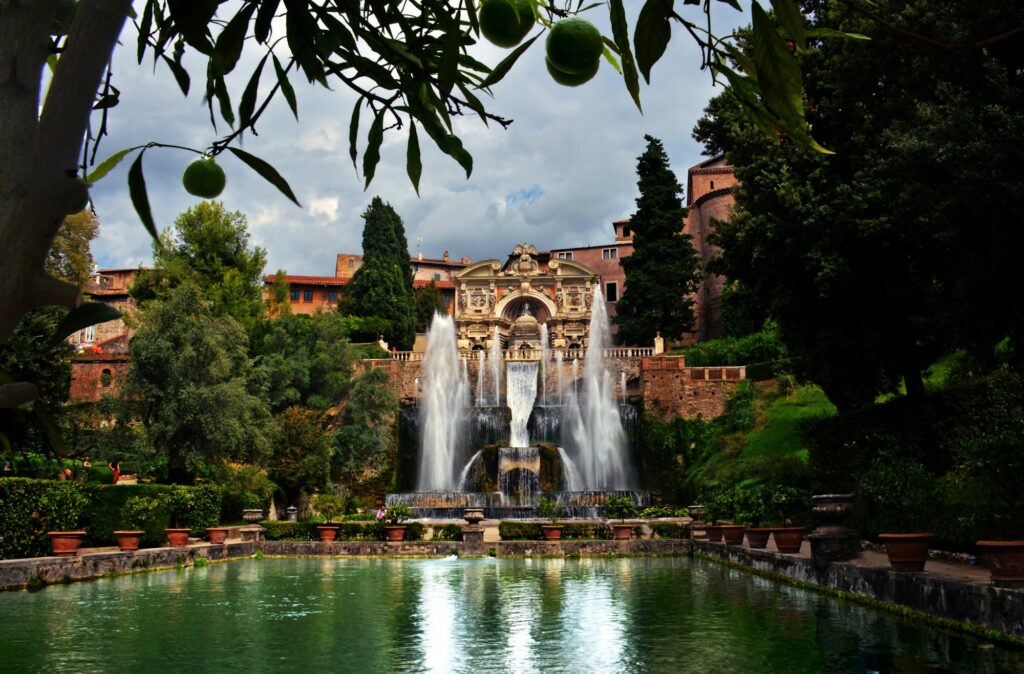Jardins en terrasses de Villa d'Este a Tivoli avec ses fontaines baroques et cypres, lumiere doree de l'apres-midi