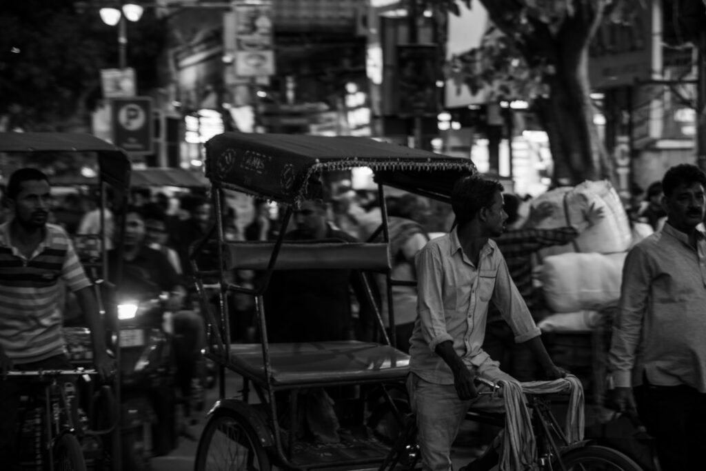 Guide et visiteurs en rickshaw traditionnel traversant les bazars de la vieille ville de Jaipur lors d'une Heritage Walk