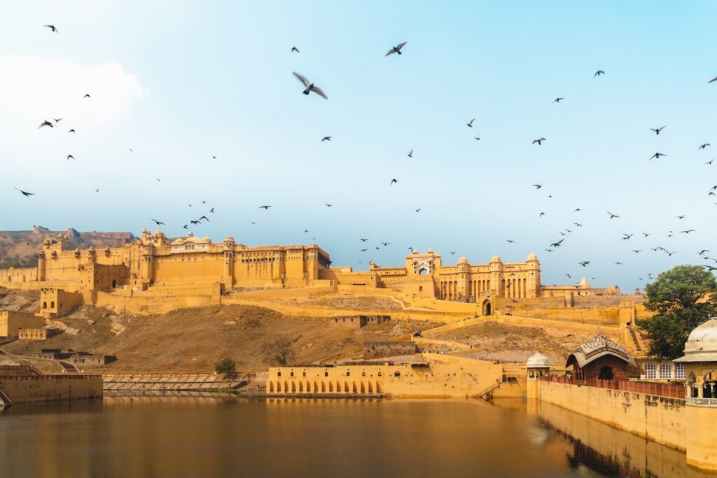 Guide privé et visiteurs devant la porte d'Amber Fort illuminée à Jaipur lors d'une journée complète de visite