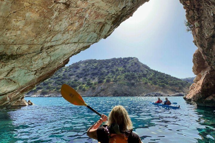 Kayak de mer vers la grotte de Rina sur la côte sauvage de Naxos, eaux claires et falaises calcaires