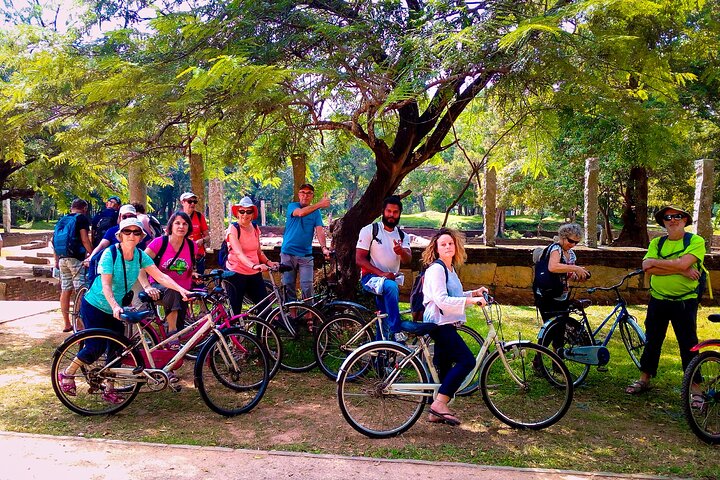 Cycliste traversant les ruines sacrées d'Anuradhapura à l'aube, stupa blanc visible au fond