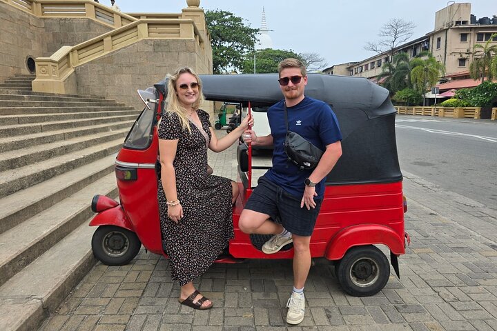 Tuk-tuk traversant les rues illuminées de Colombo devant le dagoba Sambodhi Chaithya pendant Vesak