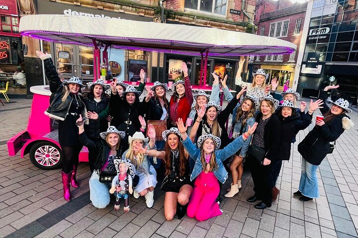 Groupe pédalant en vélo collectif party bike dans les rues de Belfast