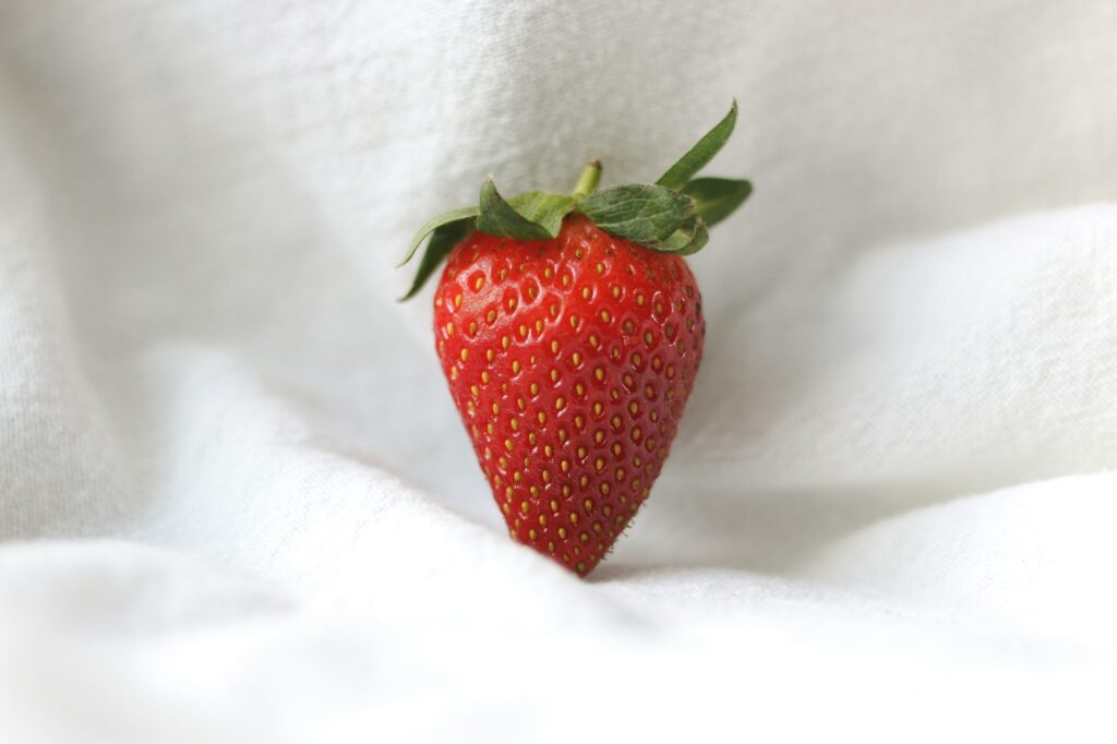 Fraises et crème avec court de tennis en gazon en arrière-plan, traditions emblématiques de Wimbledon