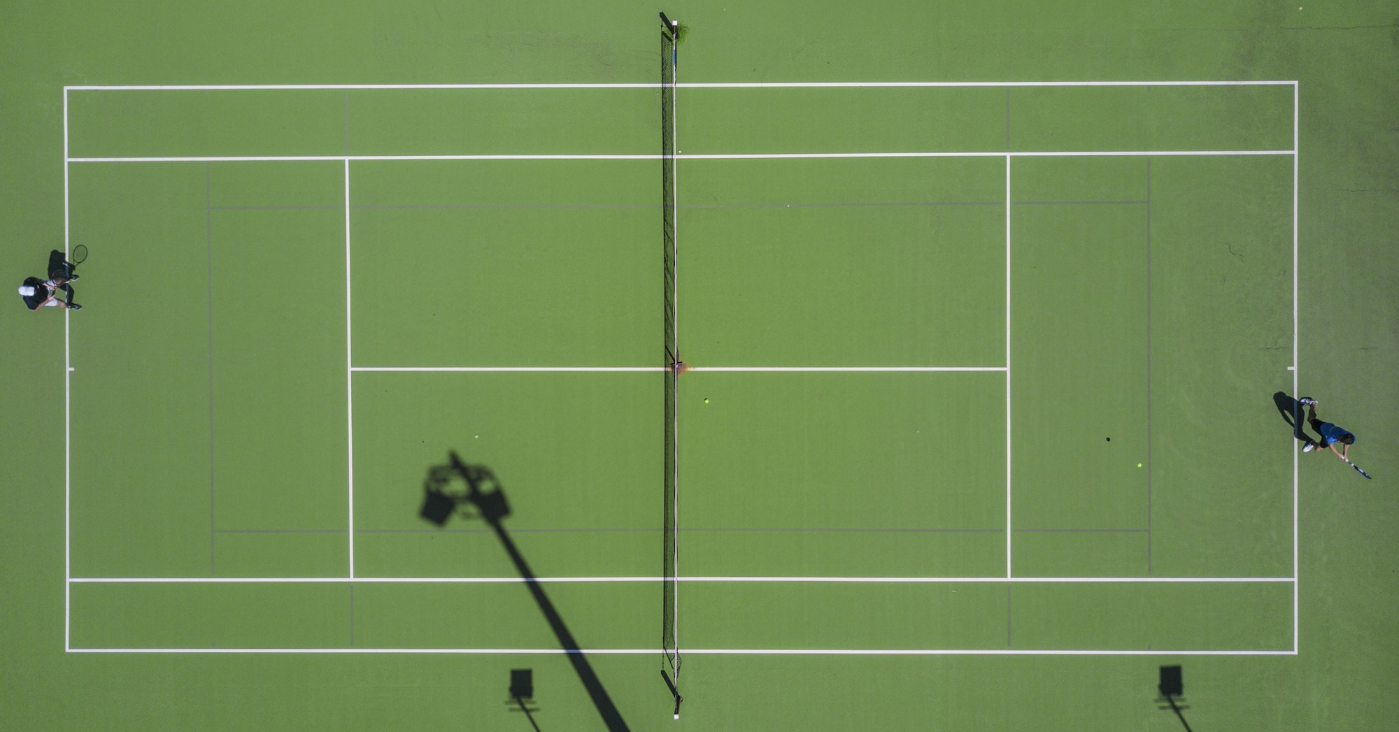 Surface de gazon vert immaculé d'un court de tennis, entretenu à 8 mm de hauteur comme à Wimbledon