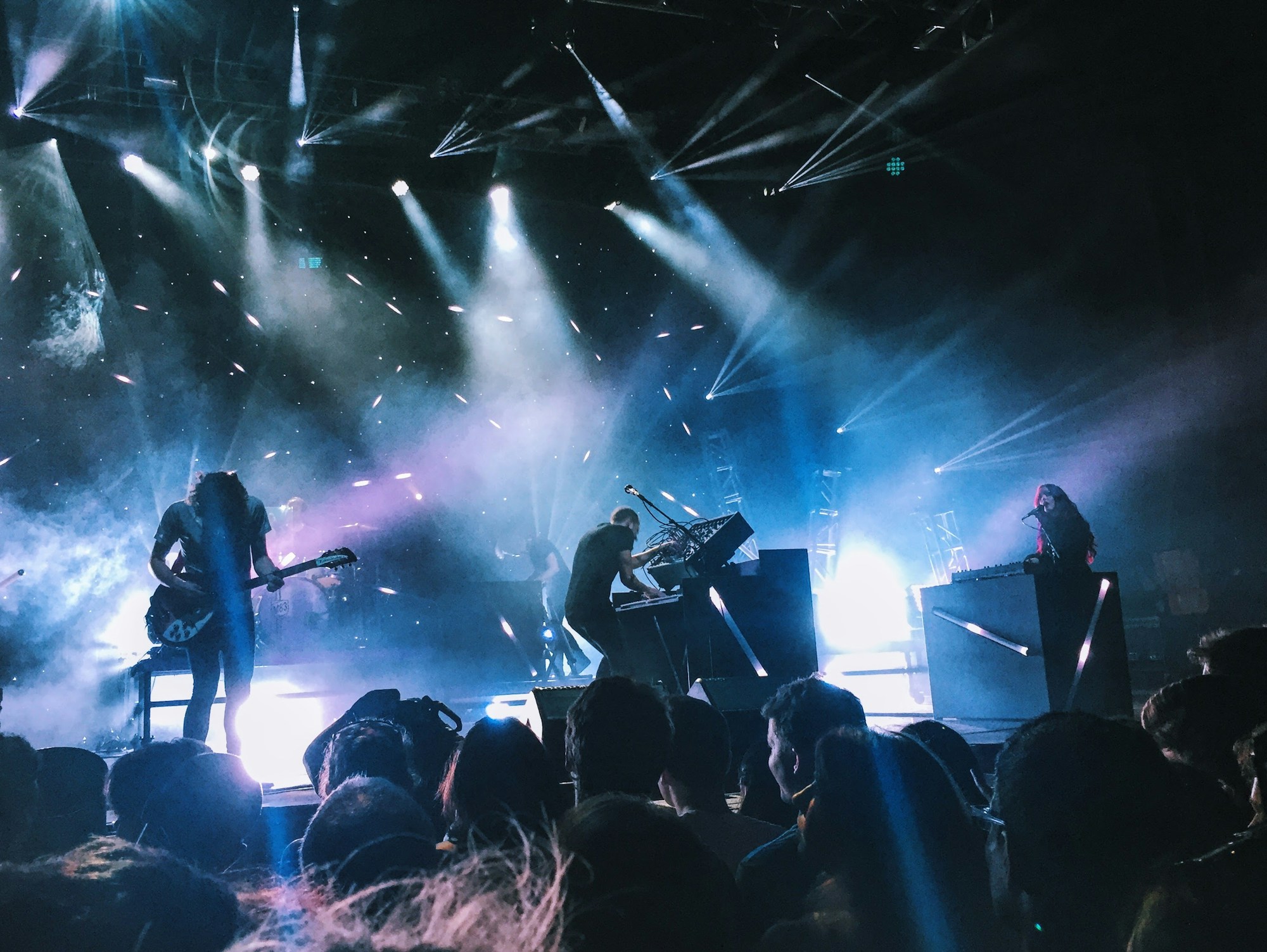 Concert de rock metal sur grande scène illuminée avec effets de lumière spectaculaires