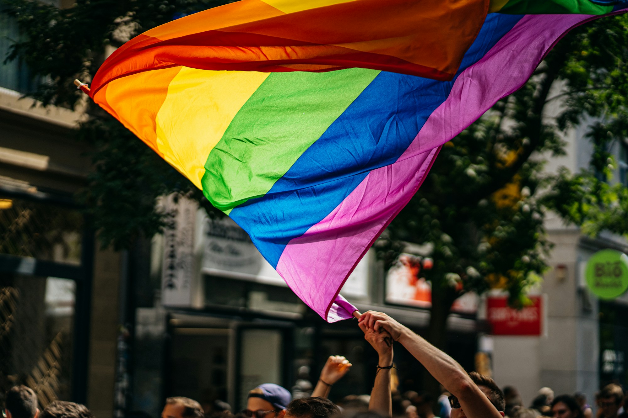 Parade de la Pride avec drapeaux arc-en-ciel et foule festive